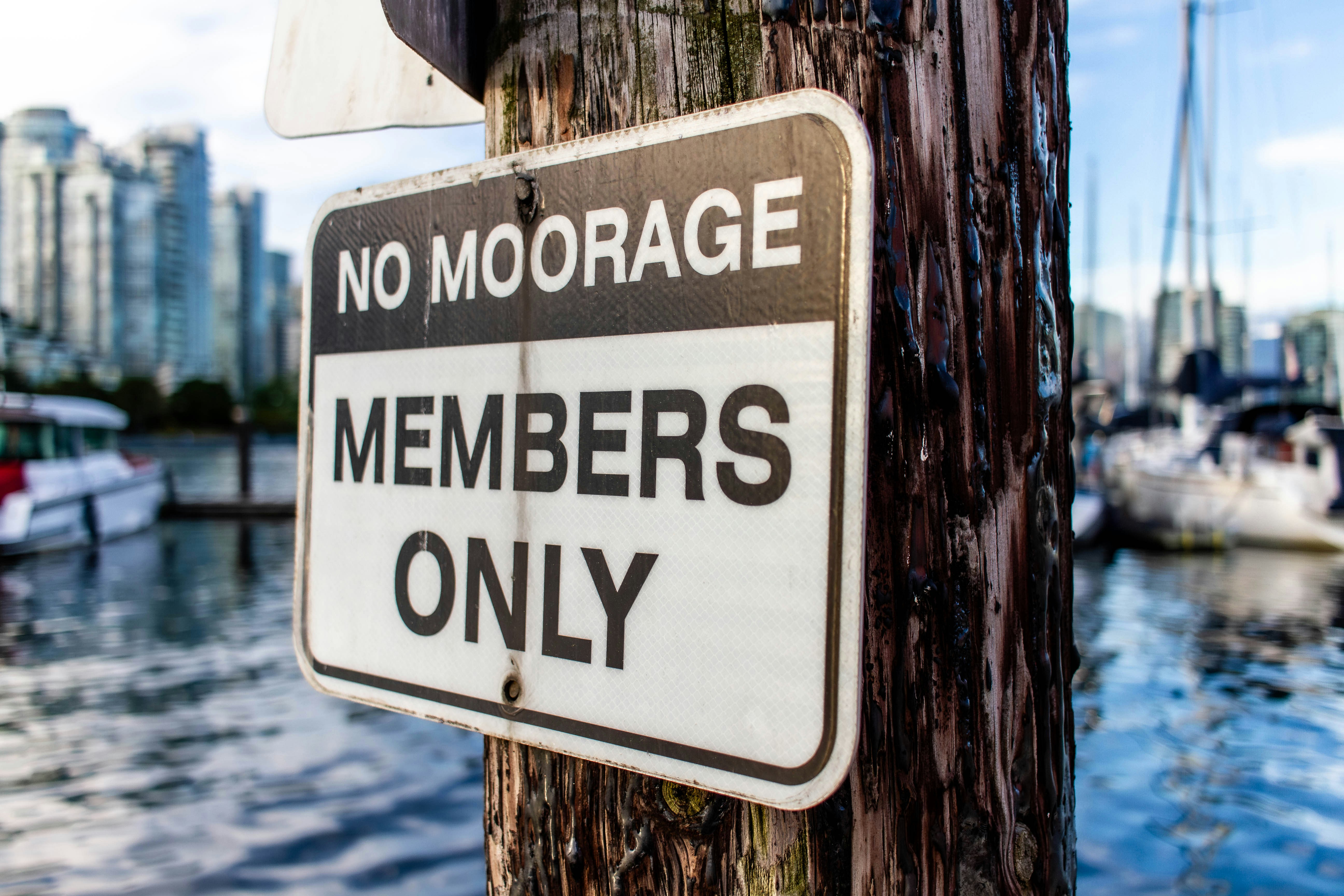 「MOORAGE MEMBER ONLY NOT」と書かれた看板が、風化した木製の柱に取り付けられていました。