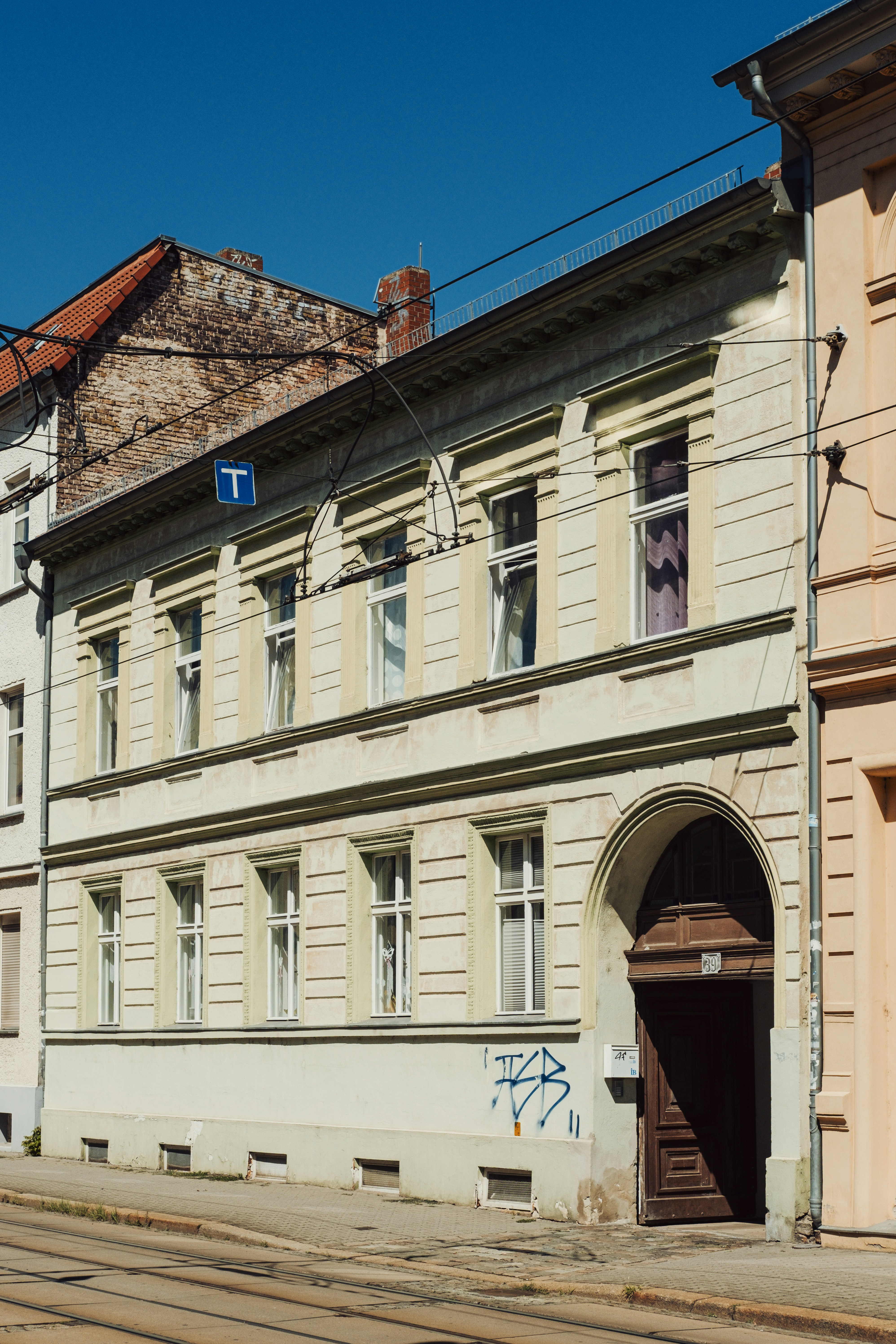 A pale yellow building with an arched doorway on a street in Brandenburg, Germany.