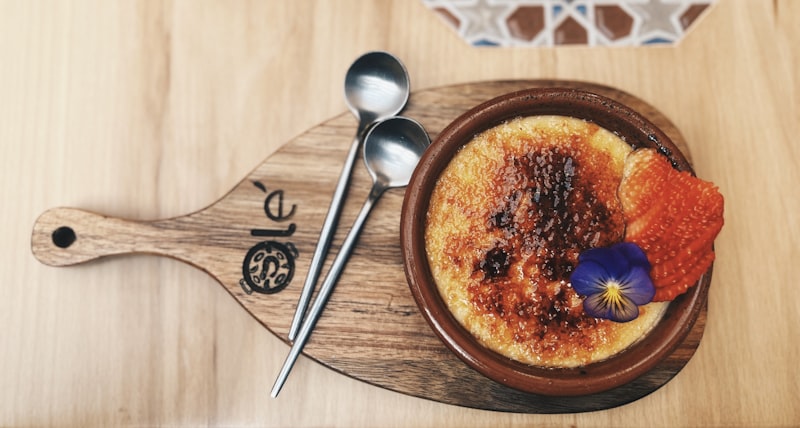 Burnt sugar custard with a strawberry on a wooden board
