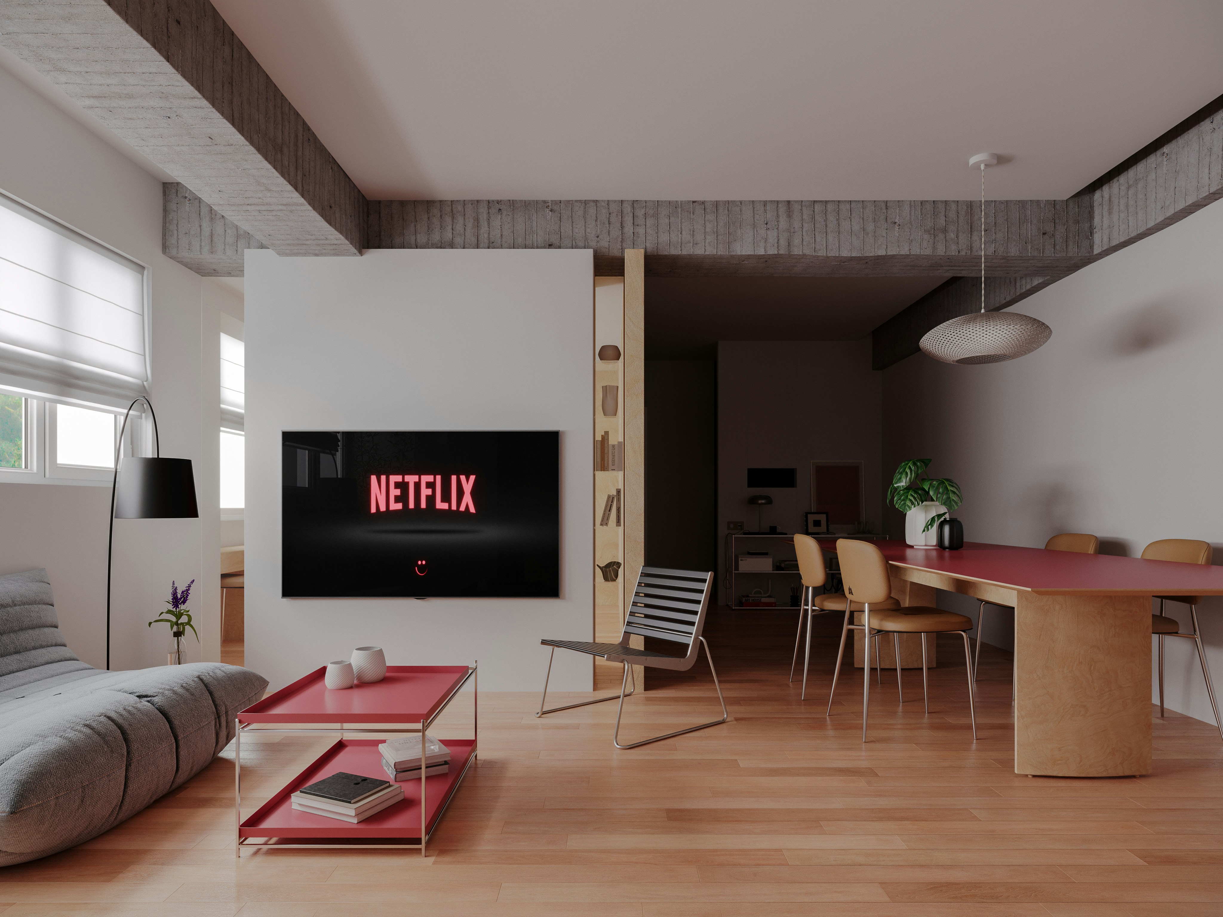 A modern living room with a television displaying a logo, red table, and chairs.