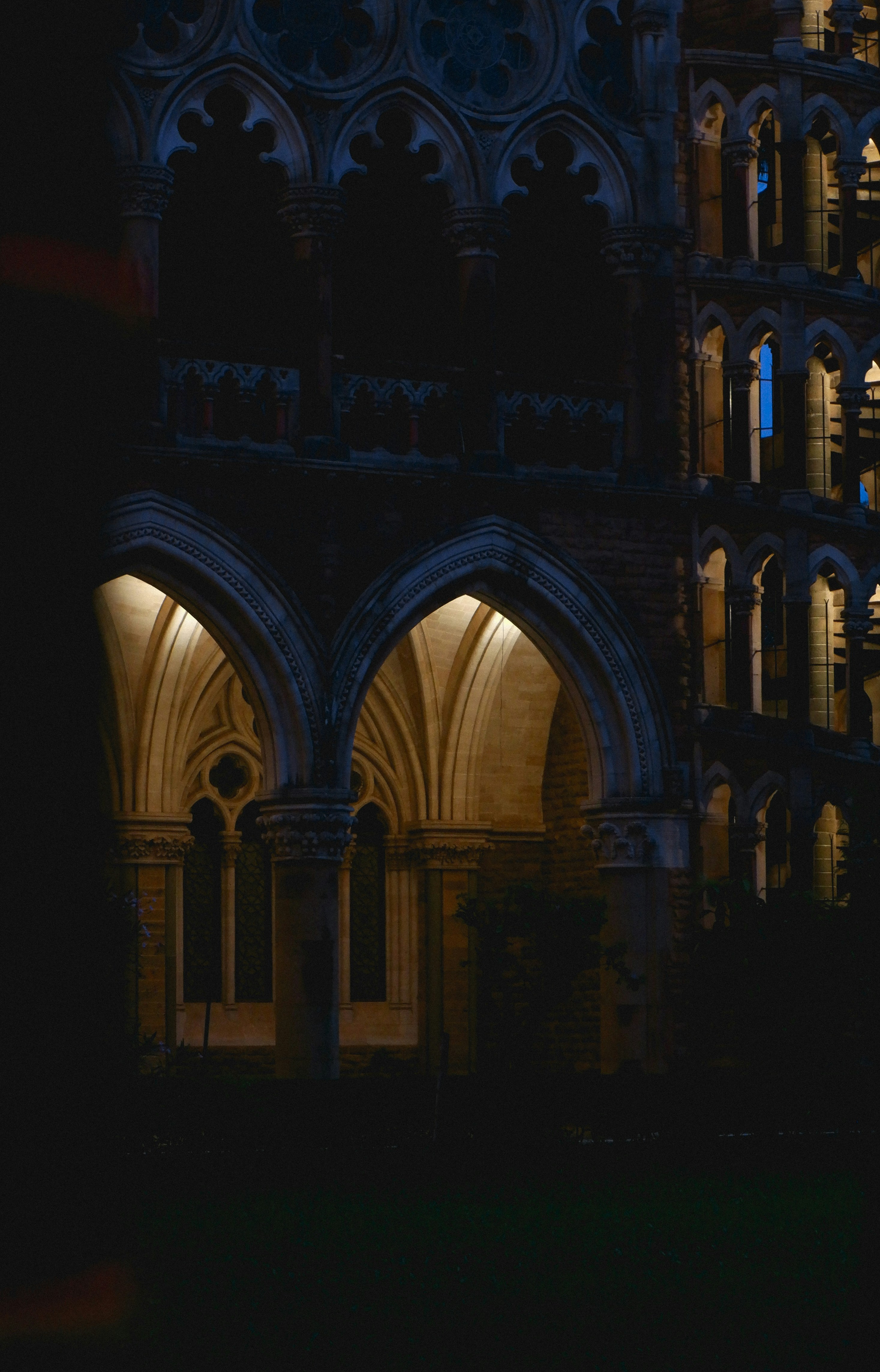 Gothic arches illuminated at night with warm interior light.