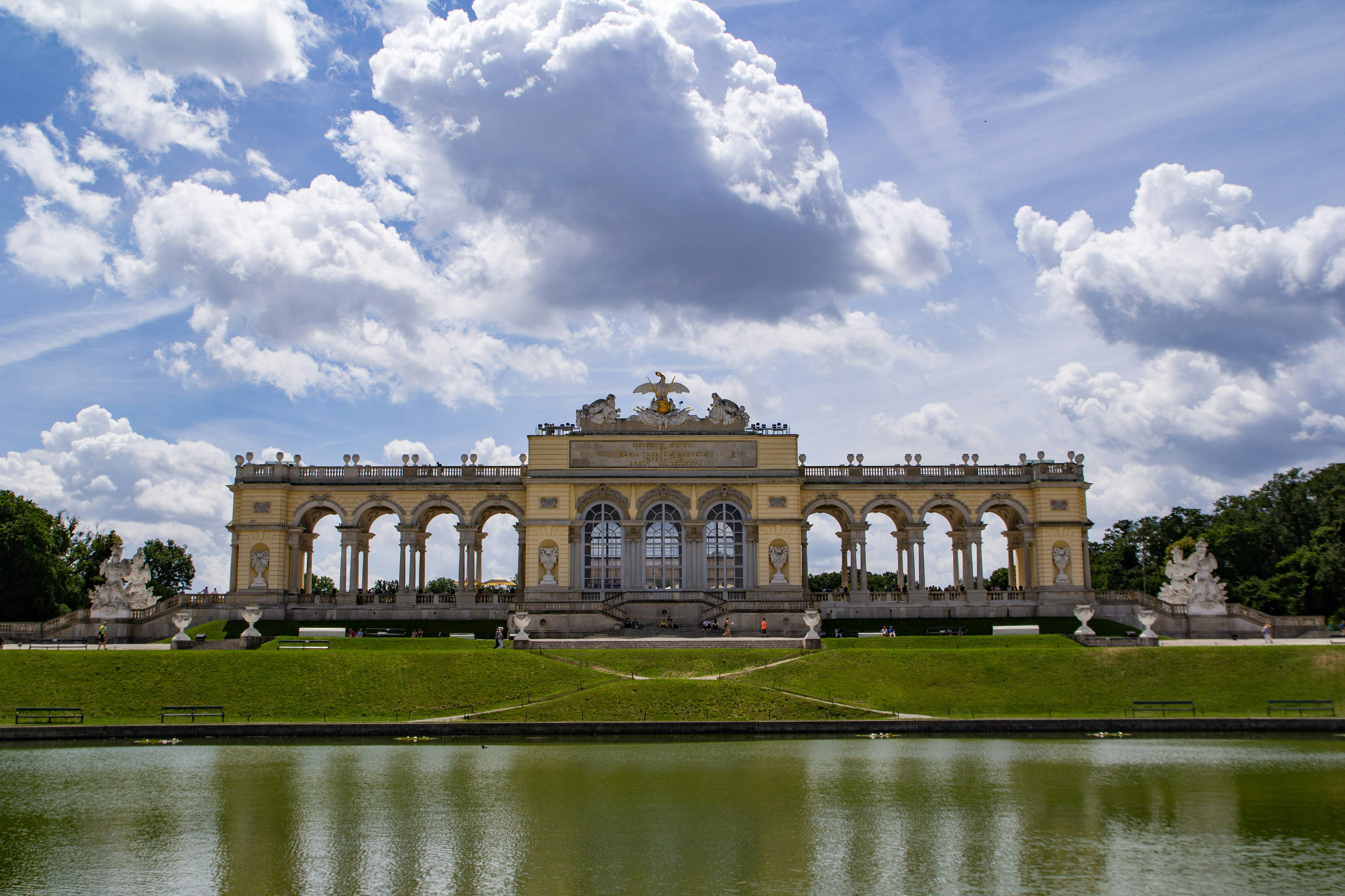 Gloriette di Istana Schönbrunn di Wina dengan kolam dan langit biru mendung