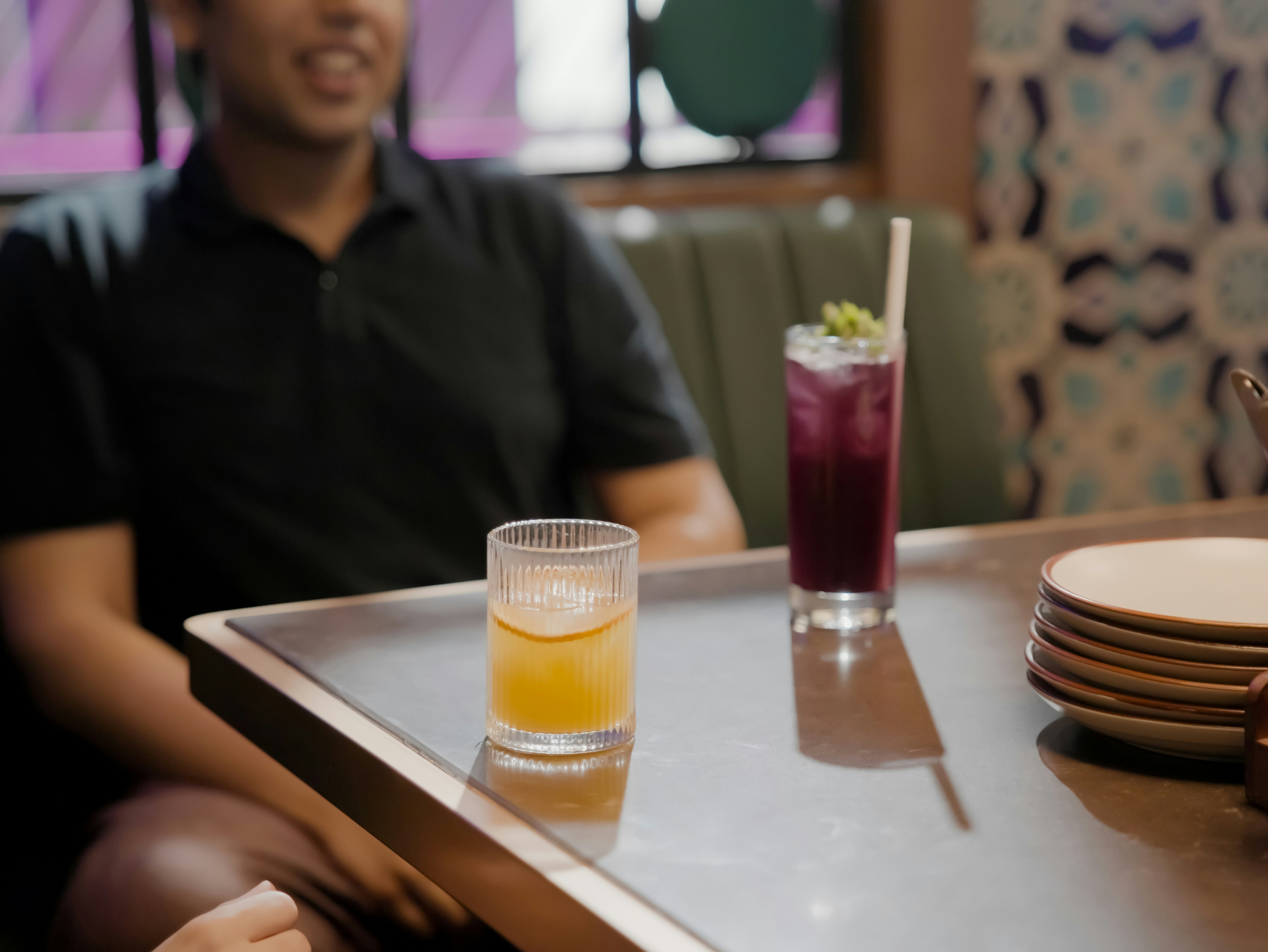 Person seated with drinks on a tray