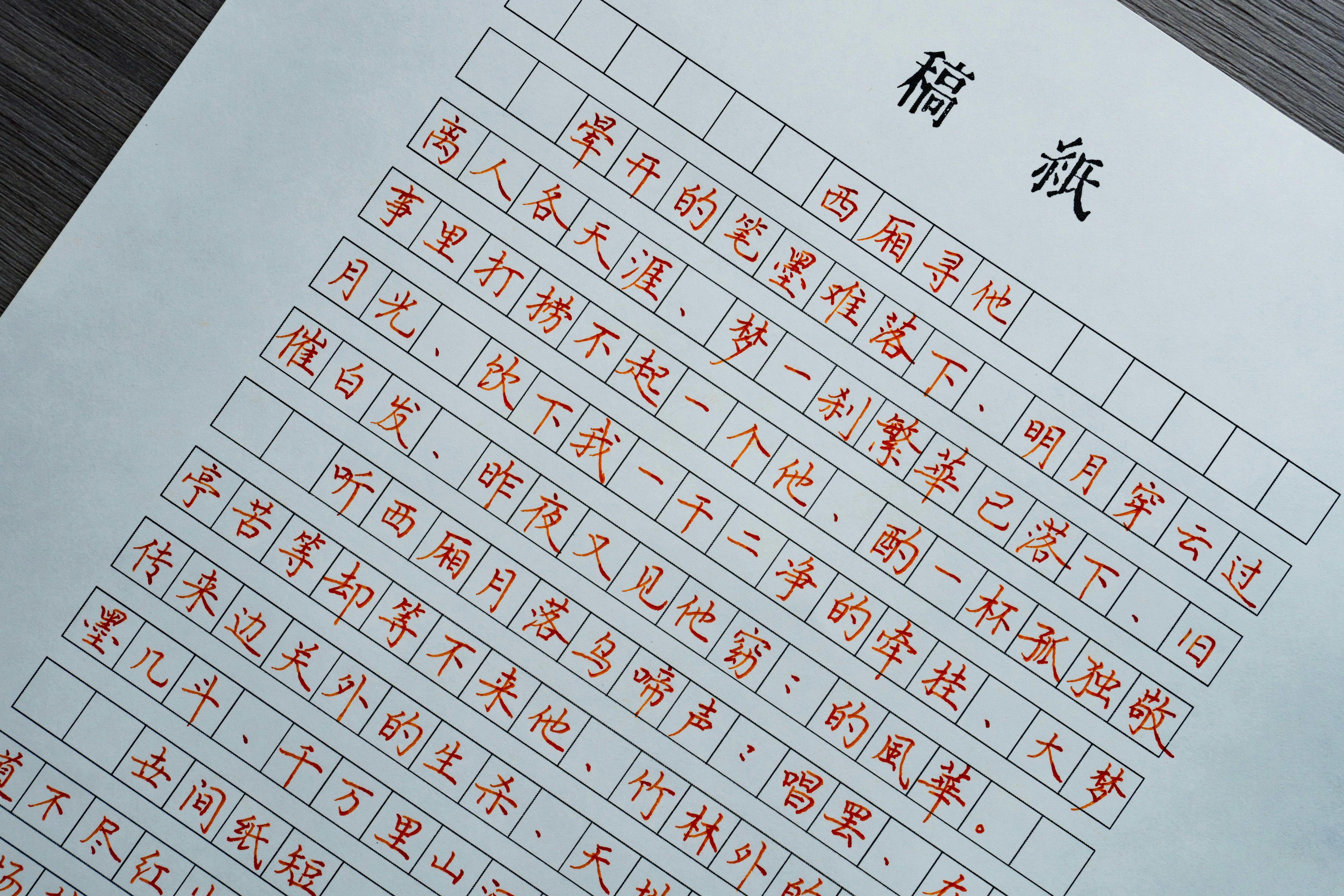 Handwritten Chinese calligraphy in red ink on a grid-lined manuscript paper