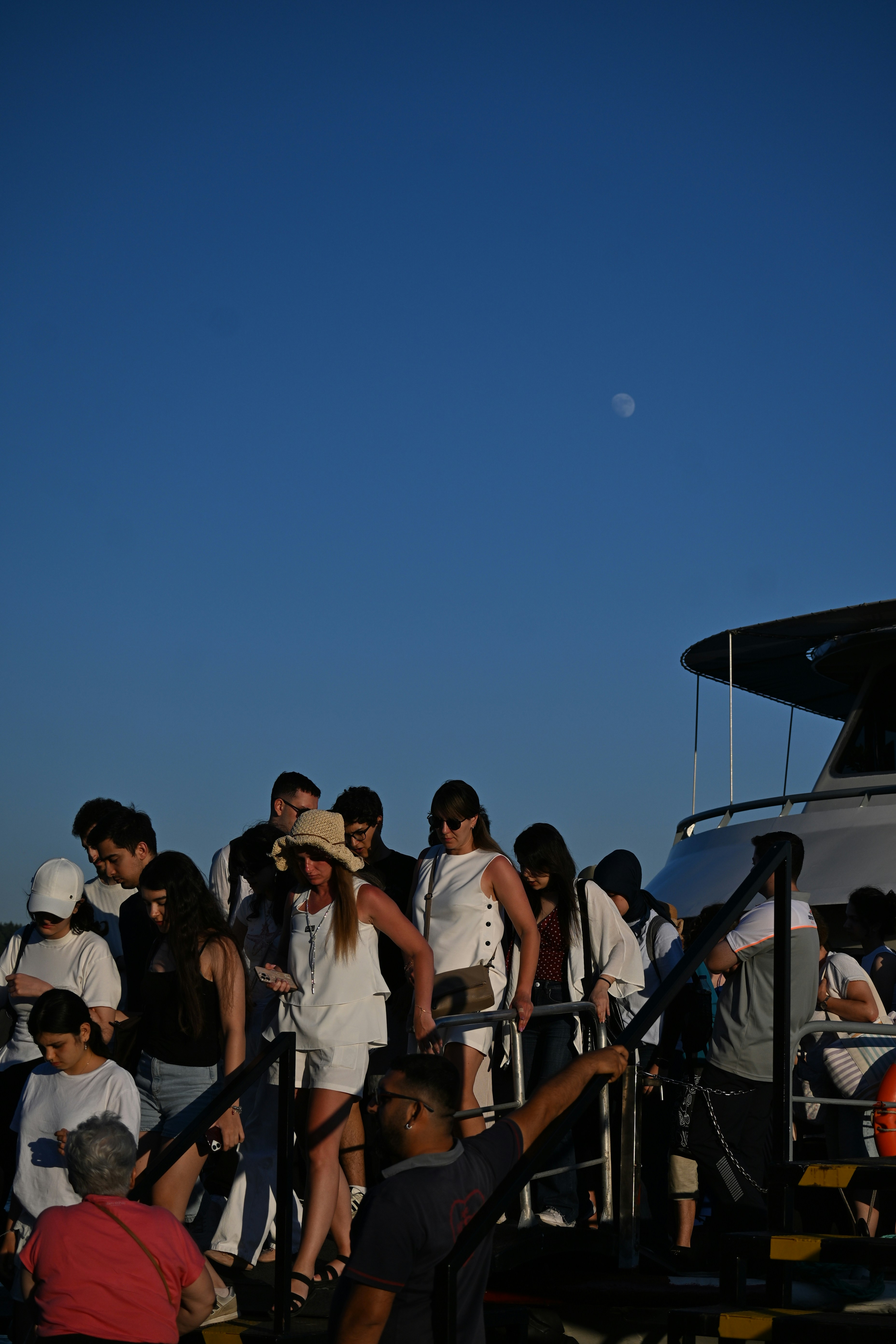 Un grupo de personas desembarcando de un barco bajo un cielo azul despejado