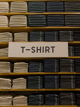 Folded cotton T-shirts stacked on shelves