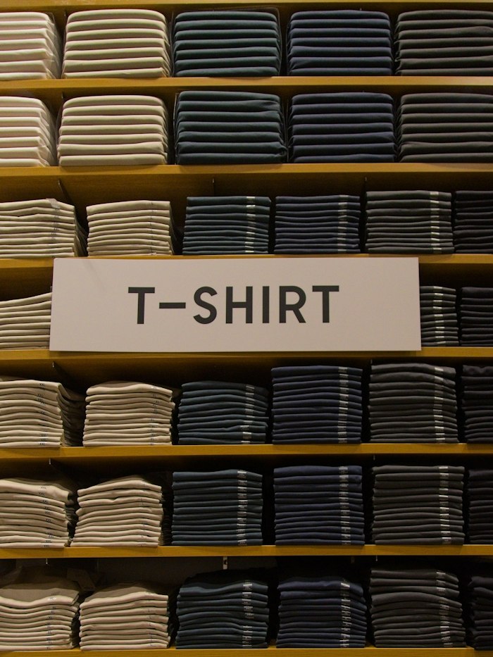 Folded cotton T-shirts stacked on shelves
