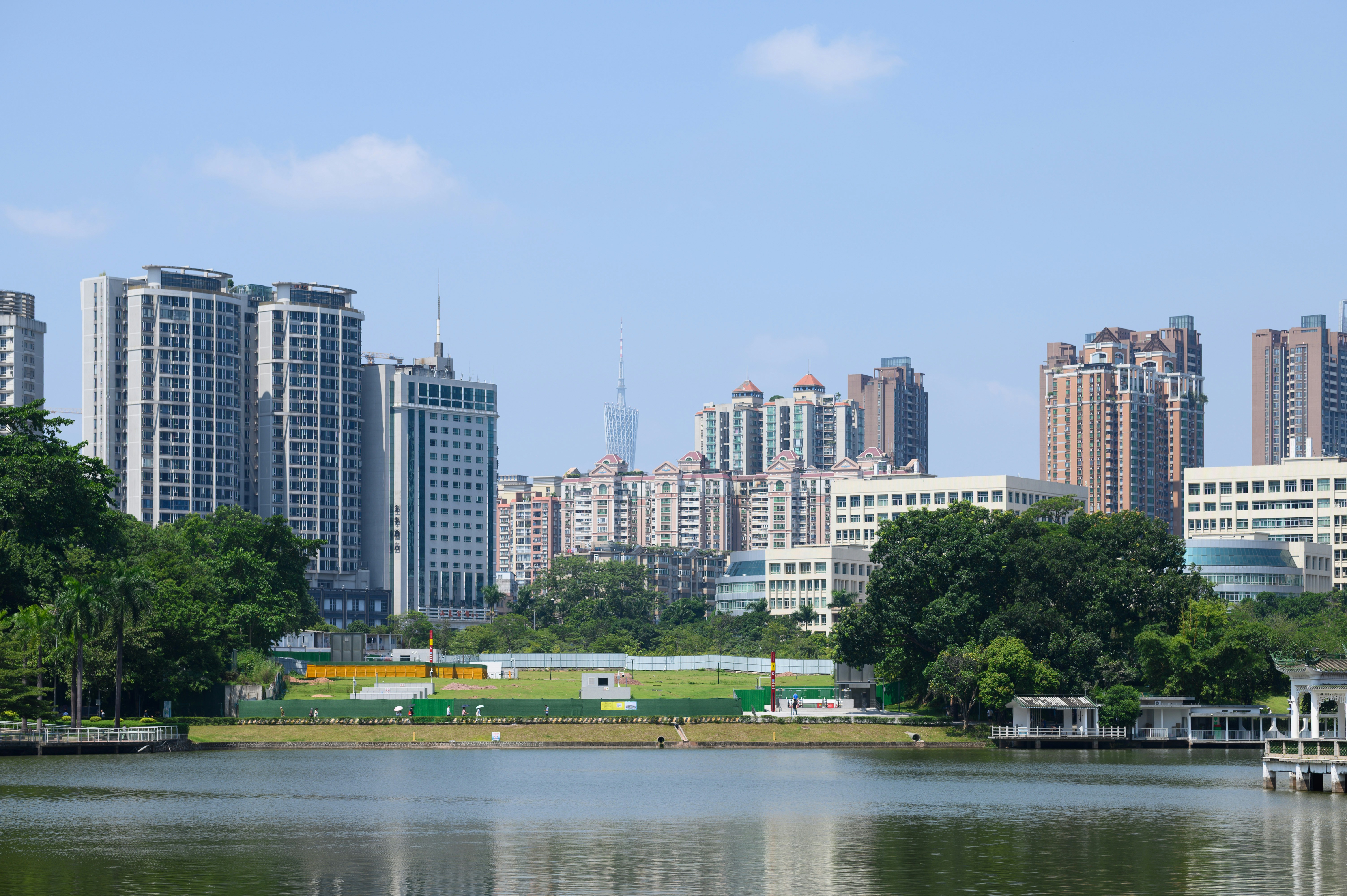 A lake in the foreground with a city skyline and the Canton Tower in Guangzhou