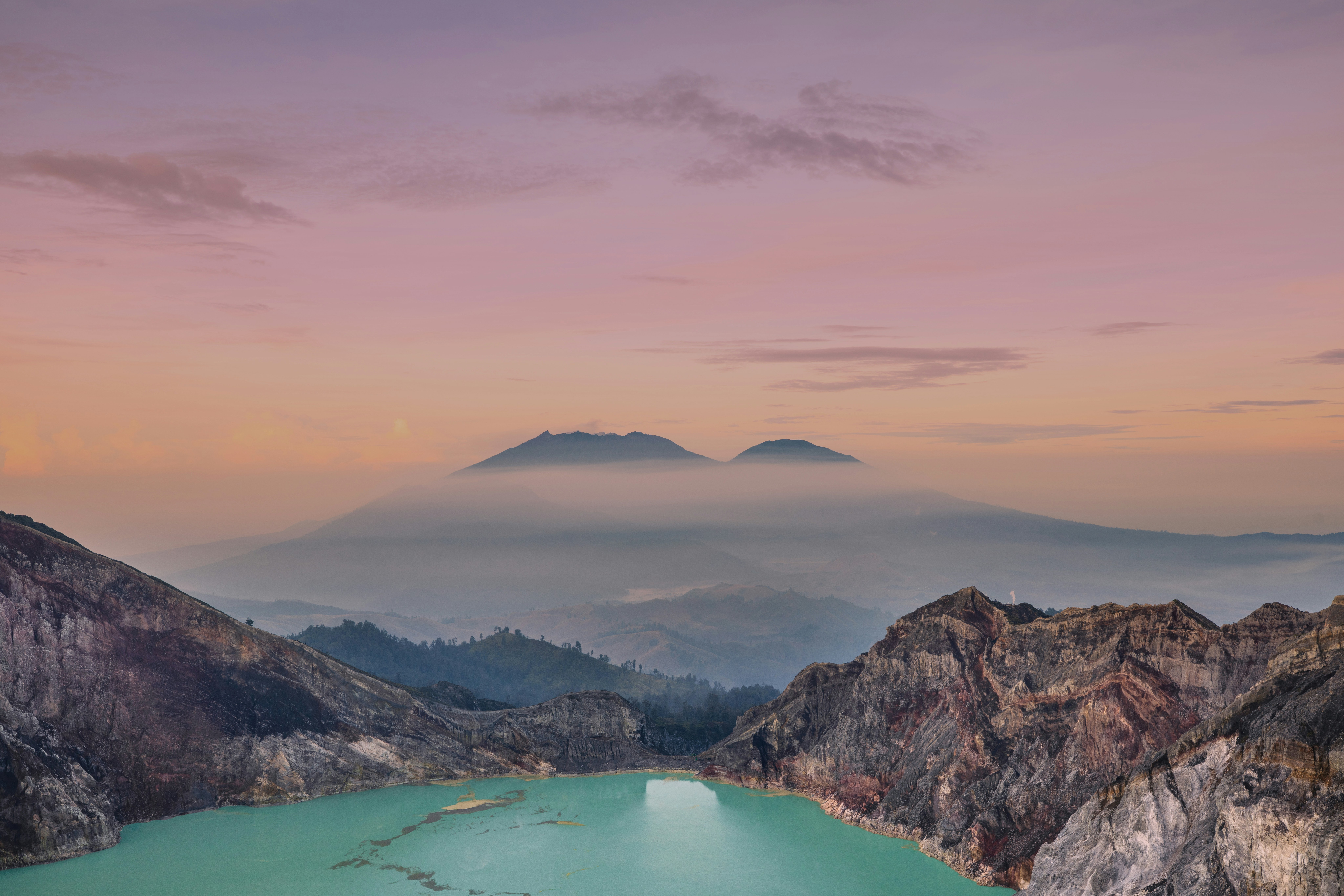 The turquoise-coloured acidic crater lake of the Ijen volcano during sunrise.