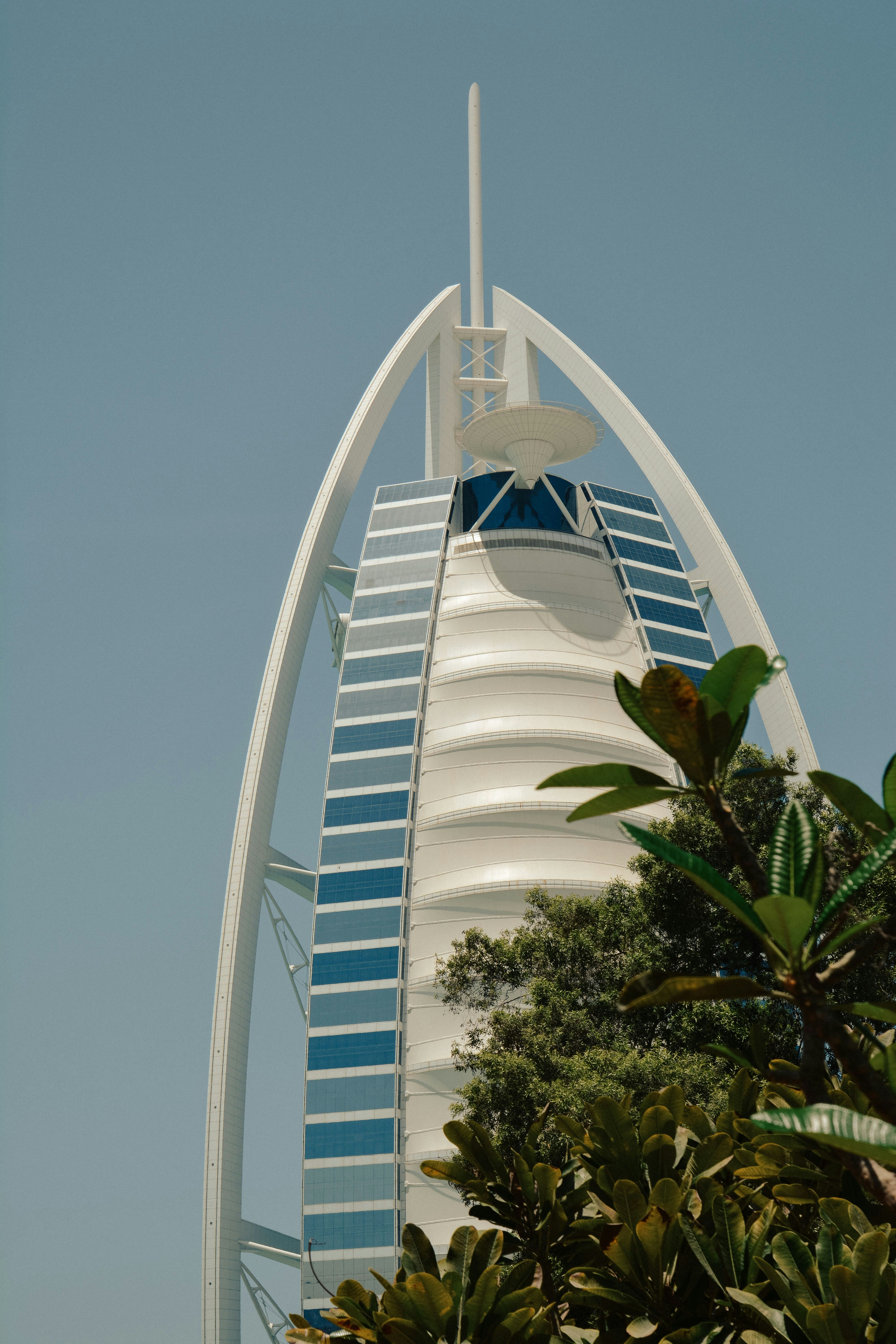The Burj Al Arab hotel in Dubai rising above green trees