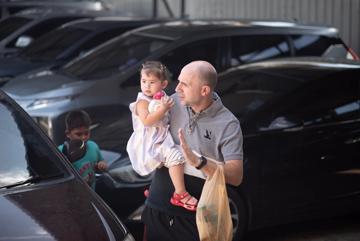 A grandfather and a young child next to the family car
