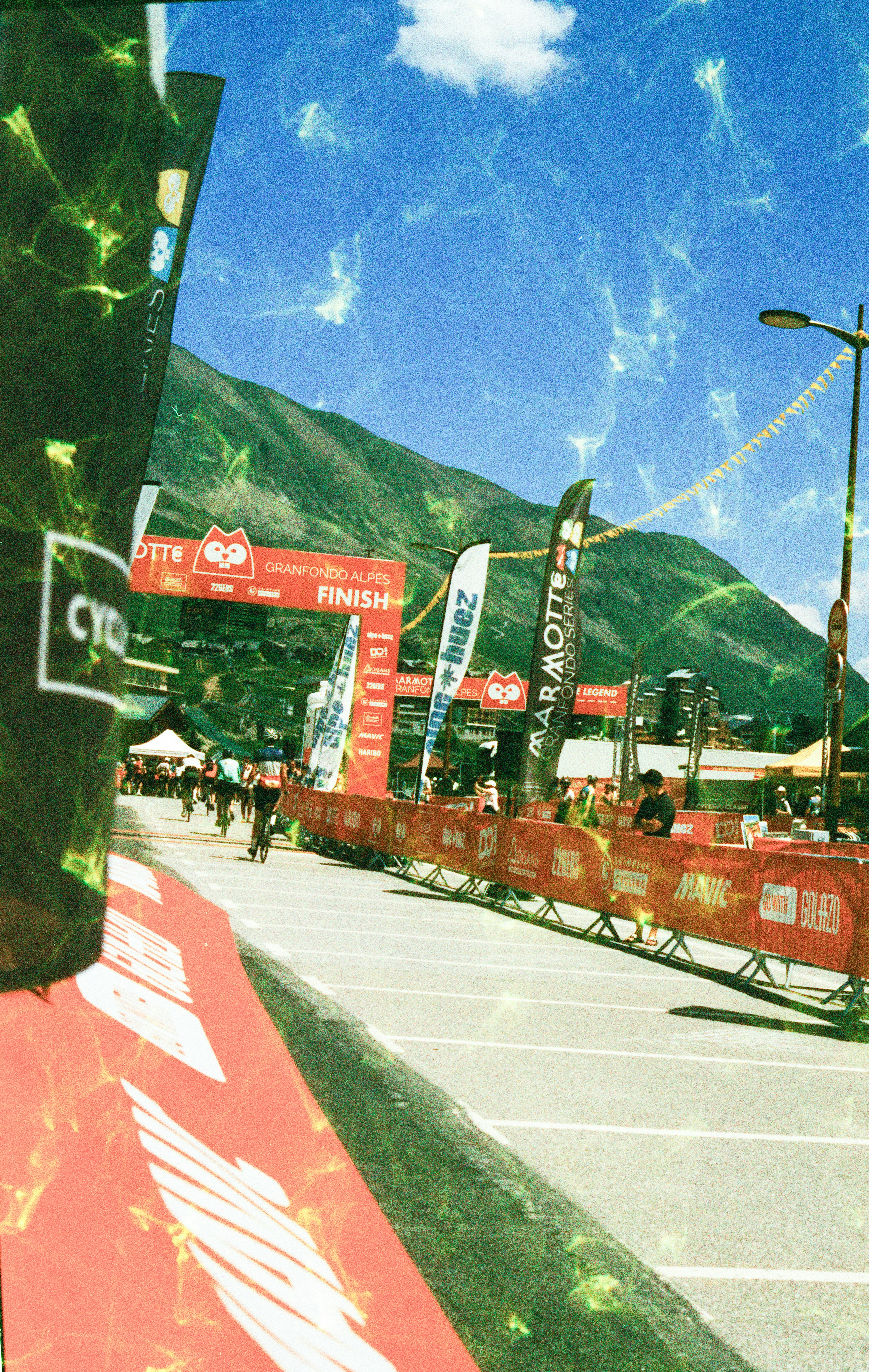 Cyclists approaching a finish line arch at the Marmotte Granfondo Alpes cycling event
