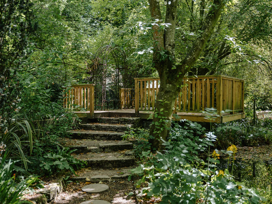 Mossy stone steps rising through lush shade planting beneath a metal garden arch