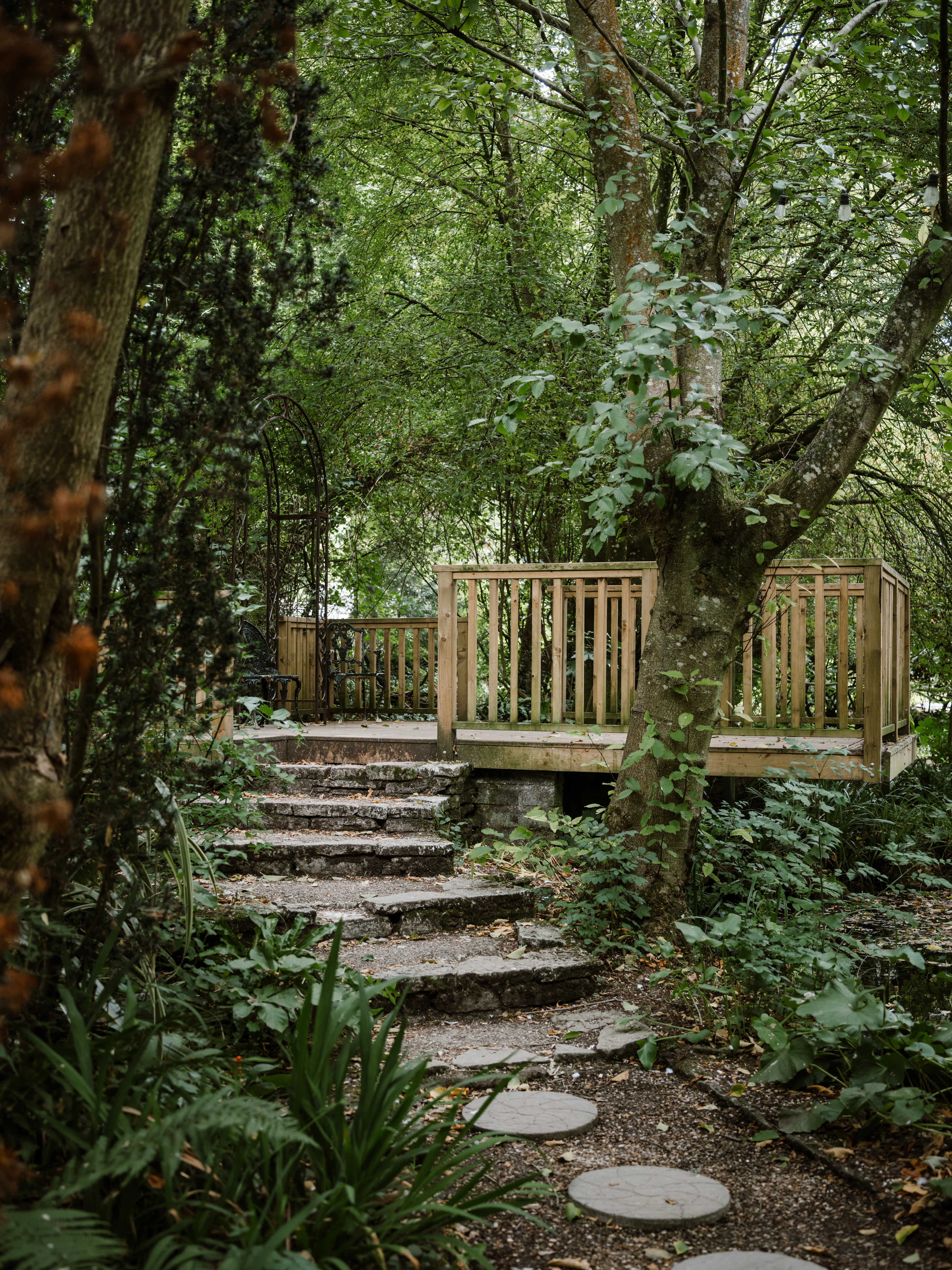 Stone steps leading to a wooden deck in a garden
