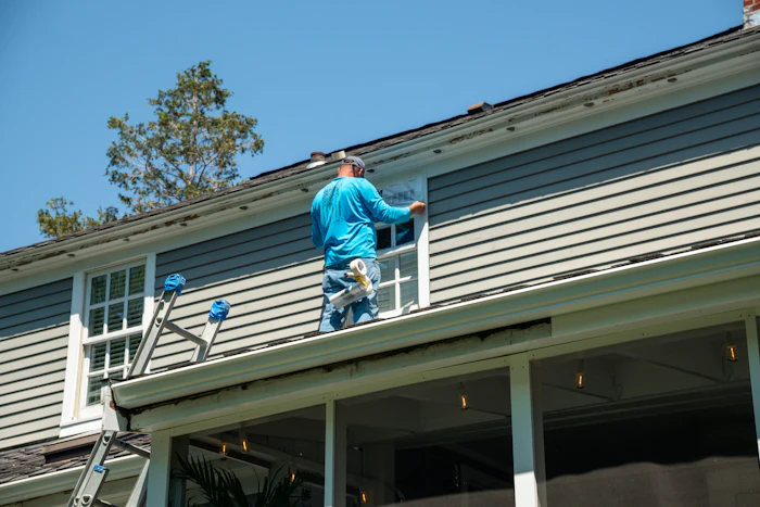Person applying tape to a window during installation