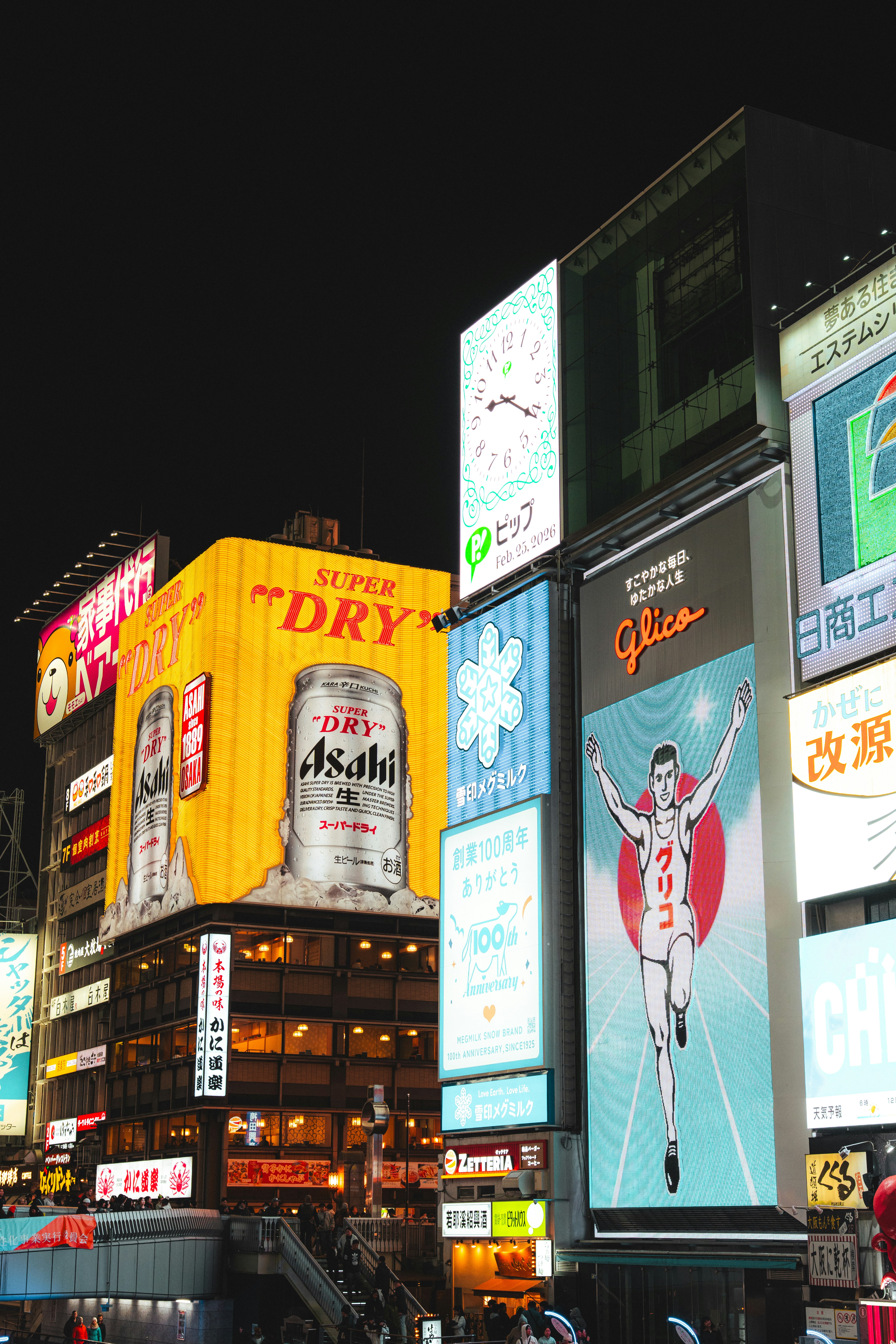Bright neon billboards and advertisements on buildings in the Dotonbori district of Osaka.