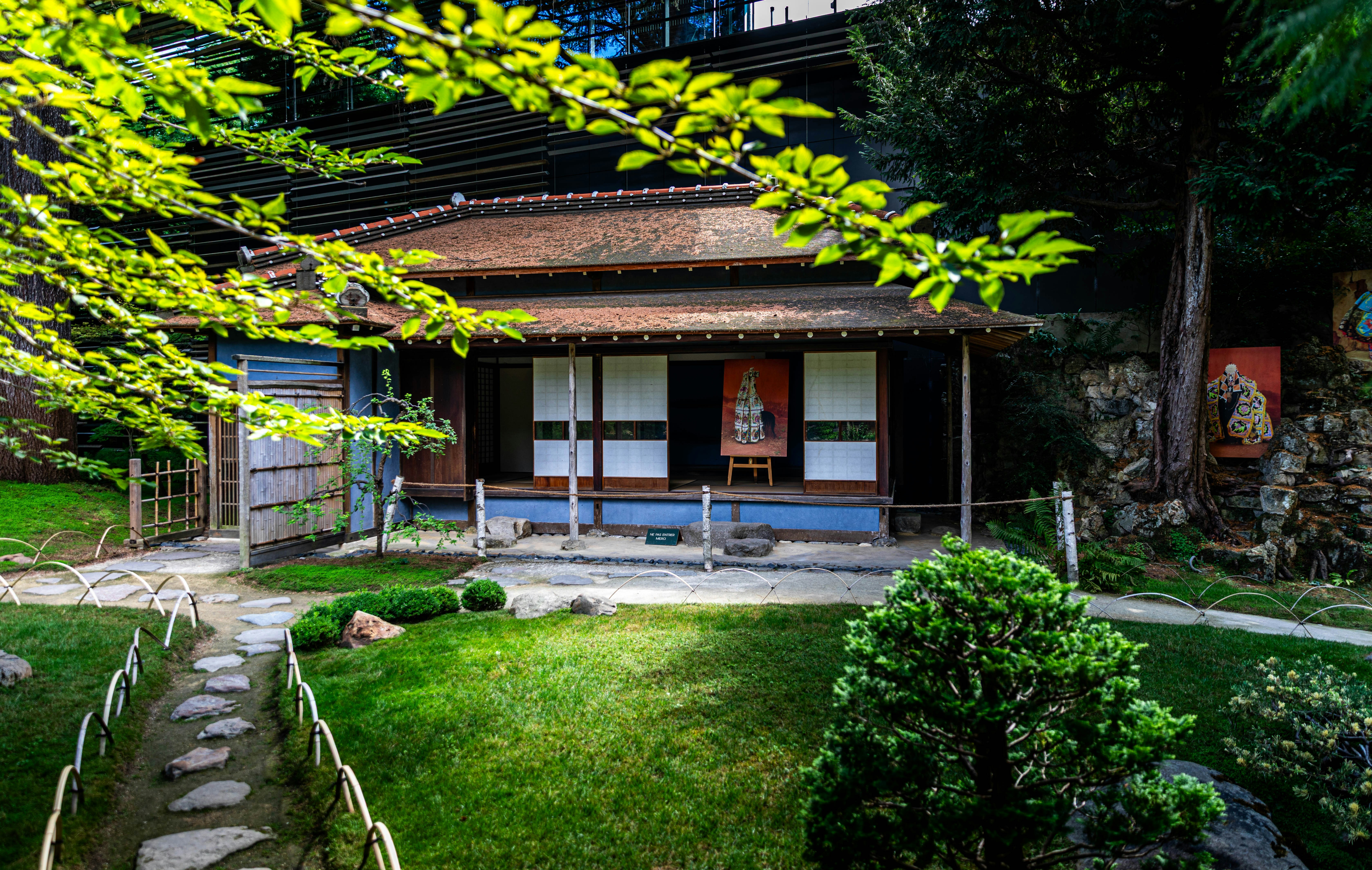 Rumah tradisional Jepang dengan atap genteng di taman hijau yang subur