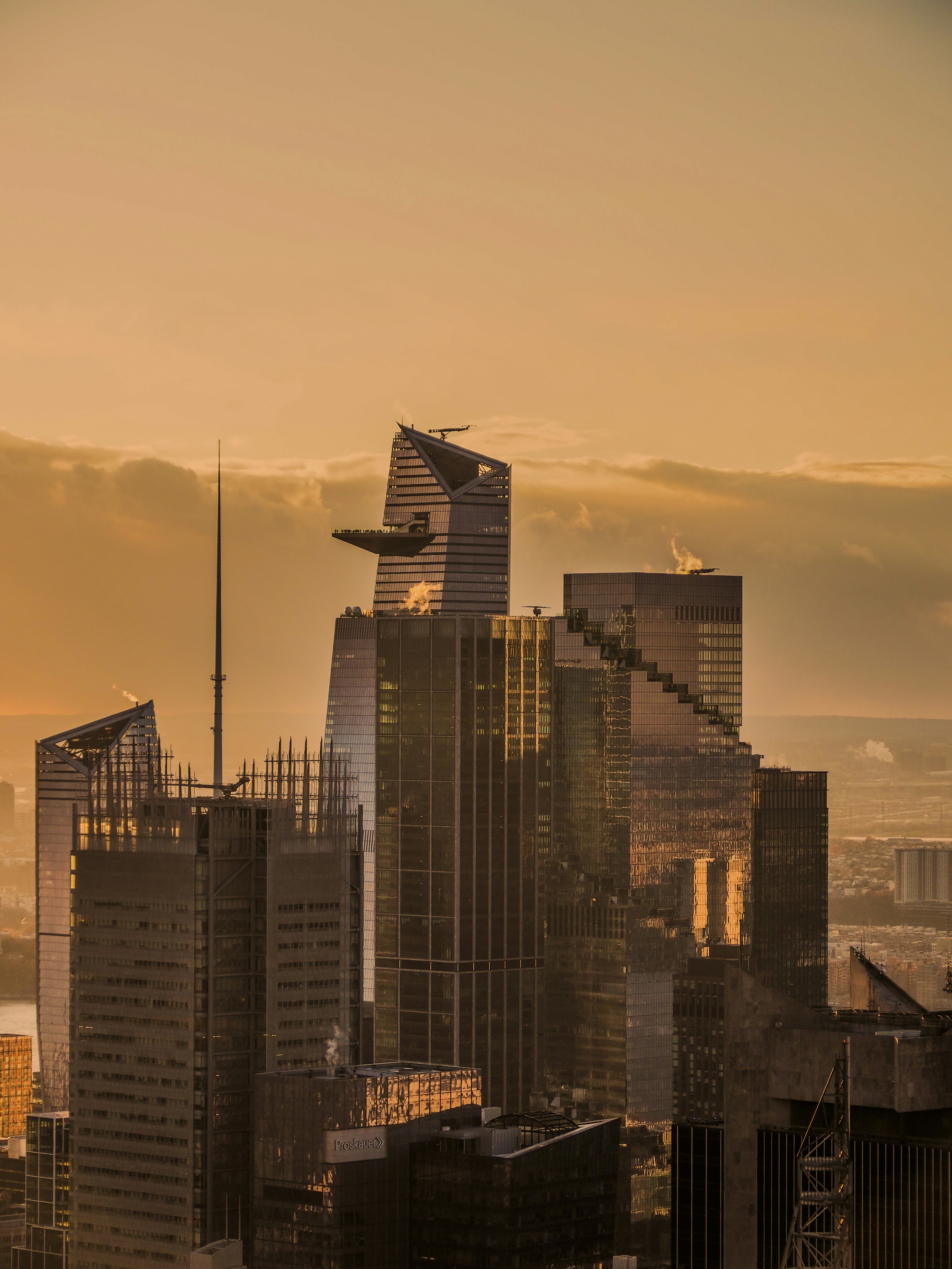 Modern skyscrapers in New York City glowing under a warm golden hour sky