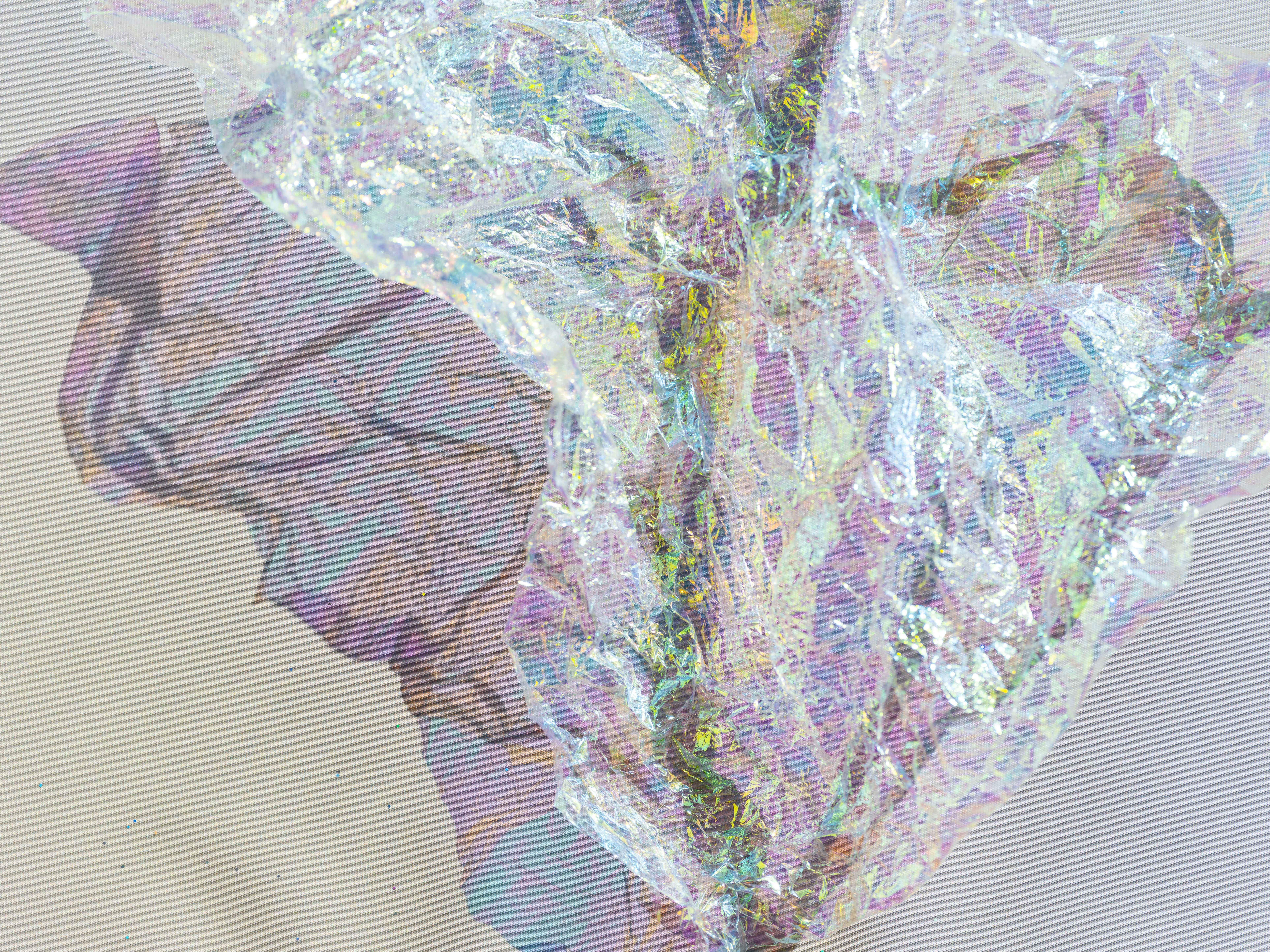 Crumpled iridescent wrapping paper on a light fabric background with soft shadows