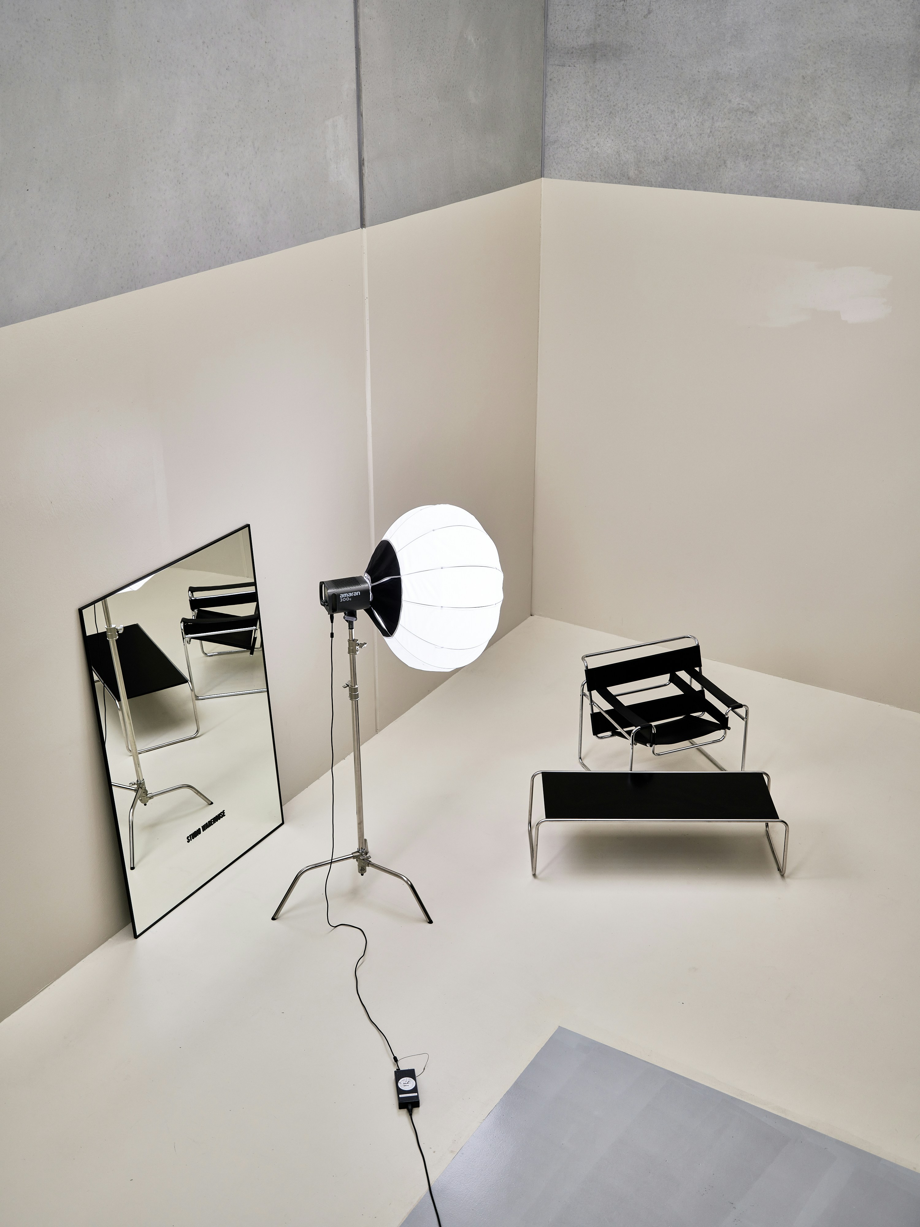 Lampu studio dengan diffuser lentera putih, kursi hitam, dan cermin