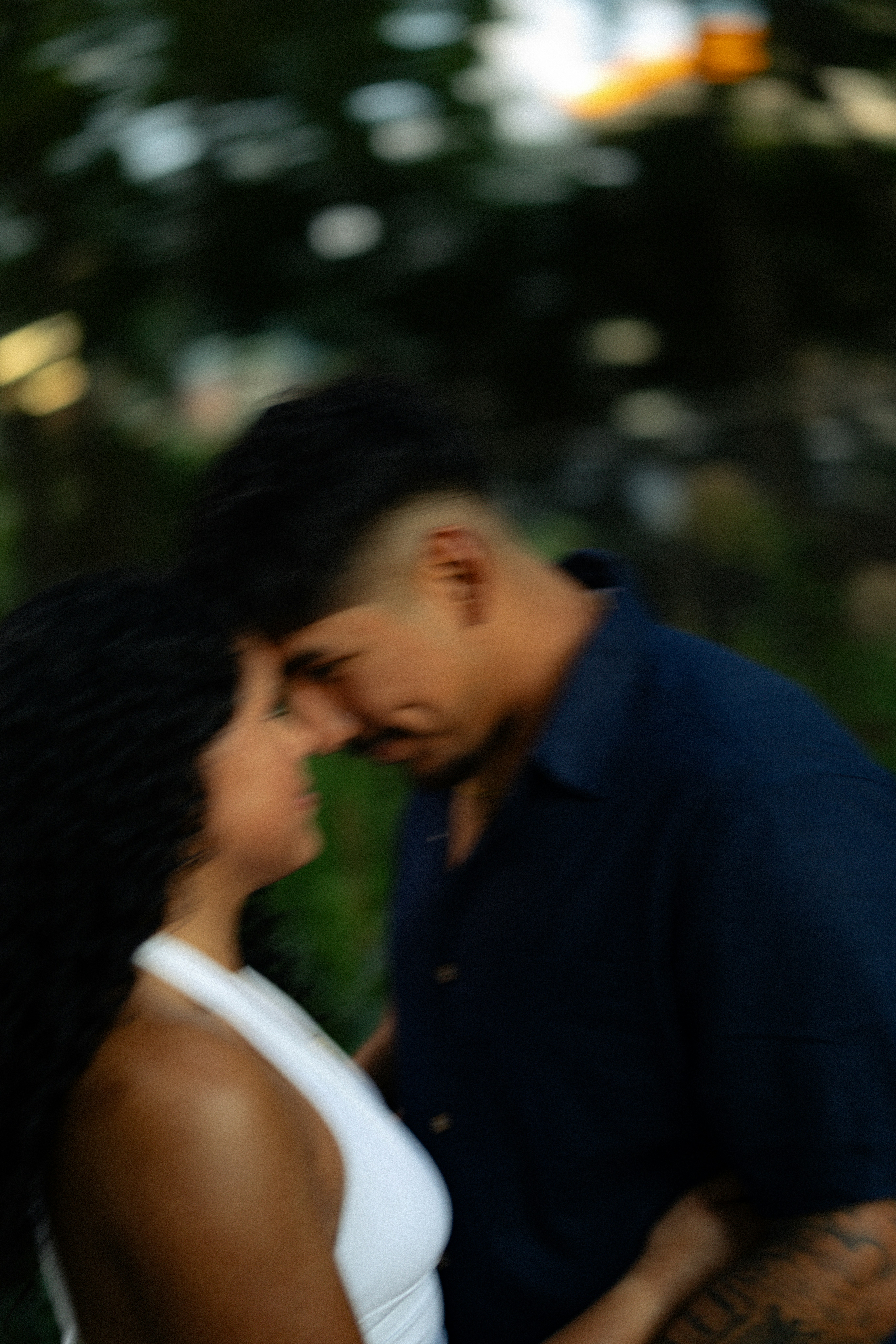 Um homem e uma mulher com testas tocando em um ambiente externo de foco suave