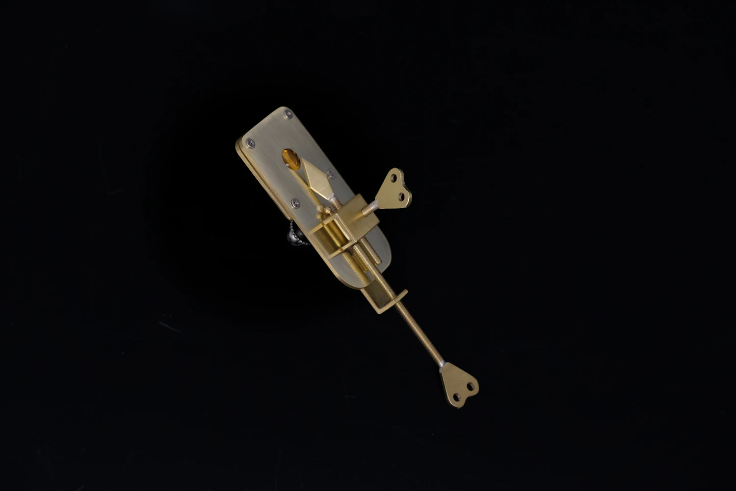 Heart-Key Movement: a brass music box movement with a heart-shaped winding key on black