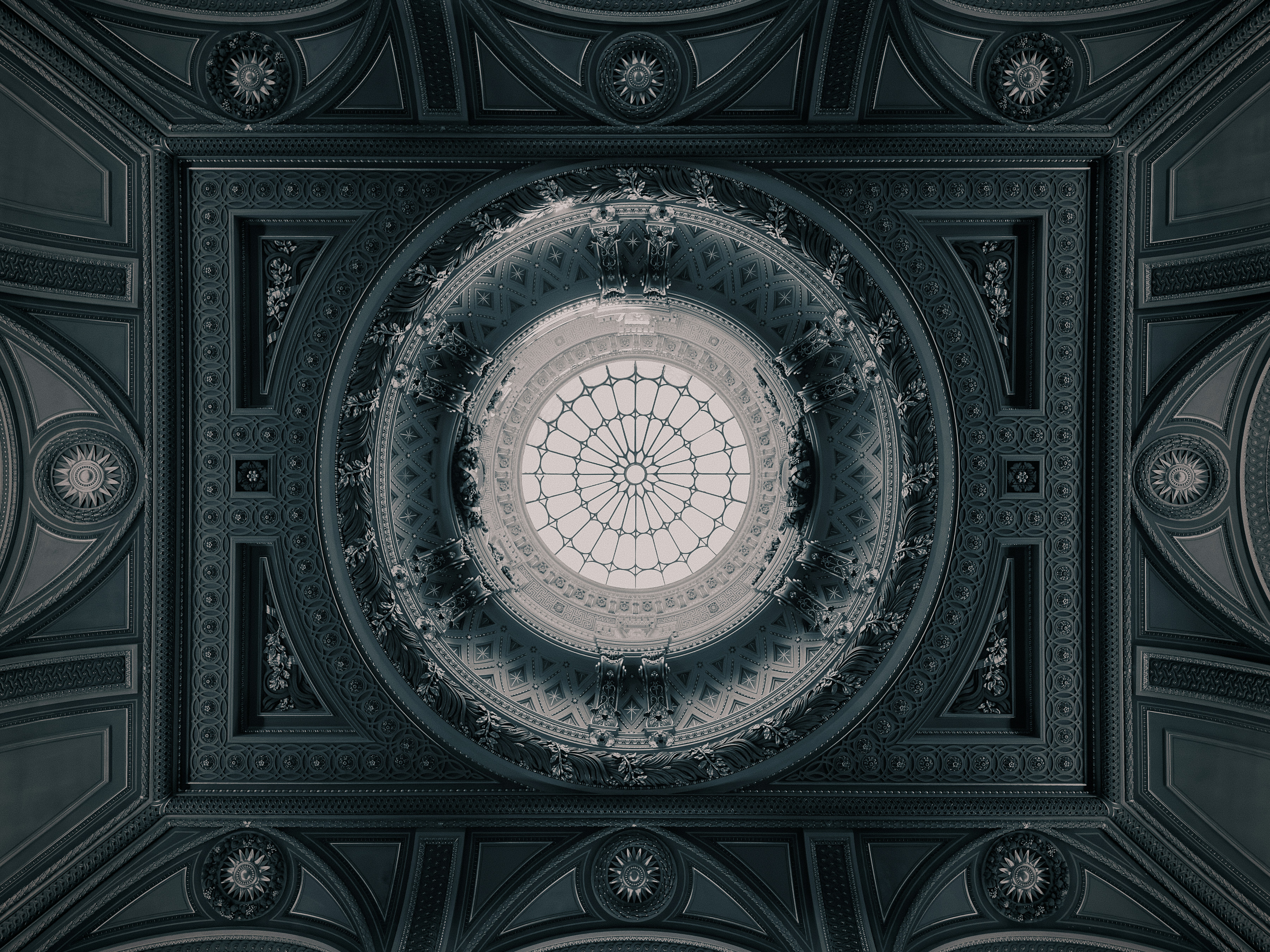 An ornate ceiling with a central glass dome at The Fitzwilliam Museum in Cambridge.