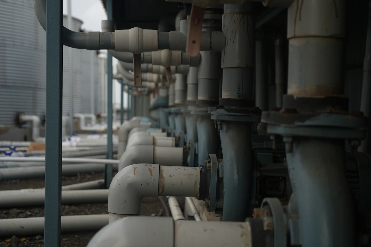 Industrial pipes and valves connected to large storage tanks