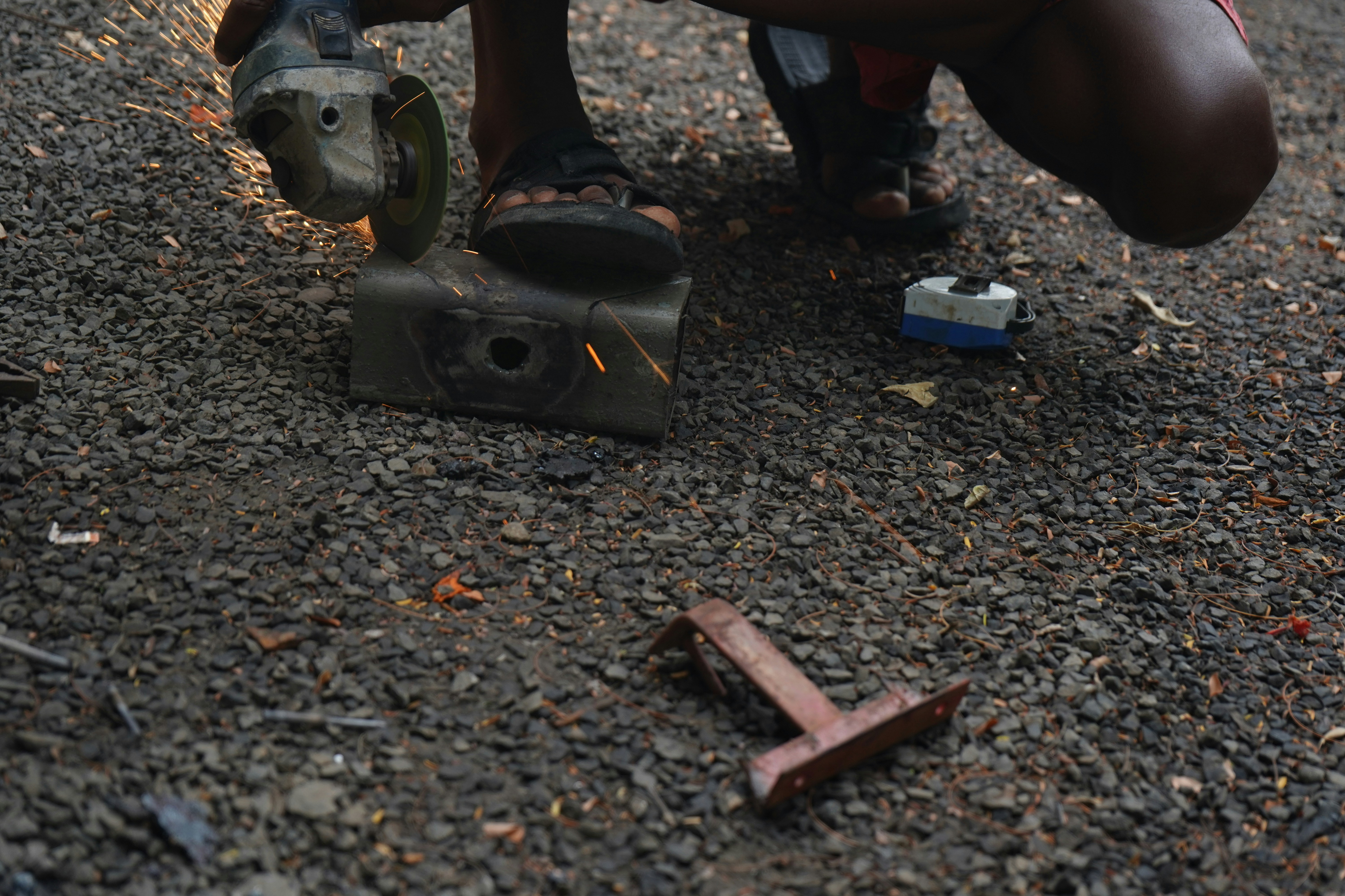 Person using an angle grinder on the ground