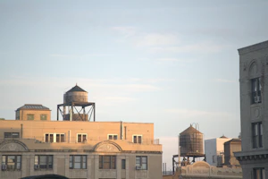 Two wooden water towers on top of brick buildings