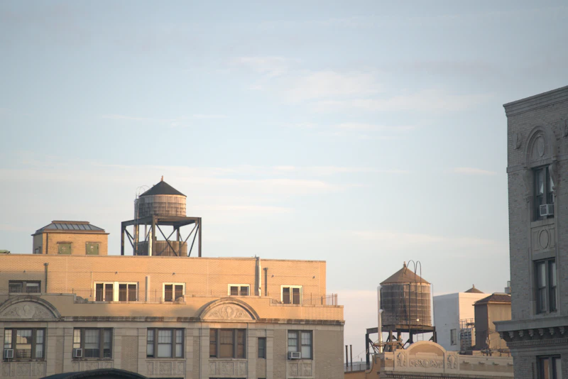 Two wooden water towers on top of brick buildings
