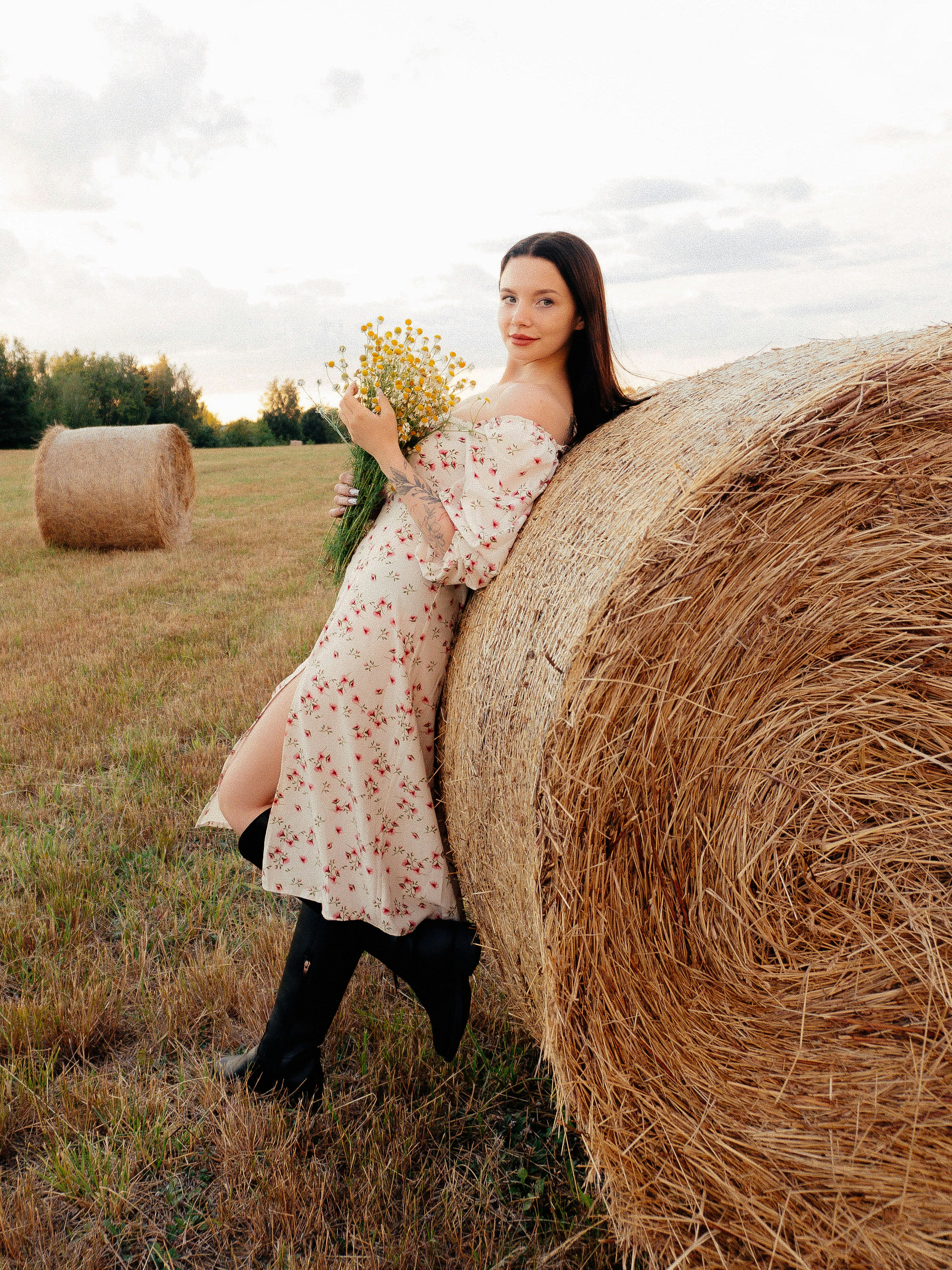 Cream floral dress leaning on a hay bale
