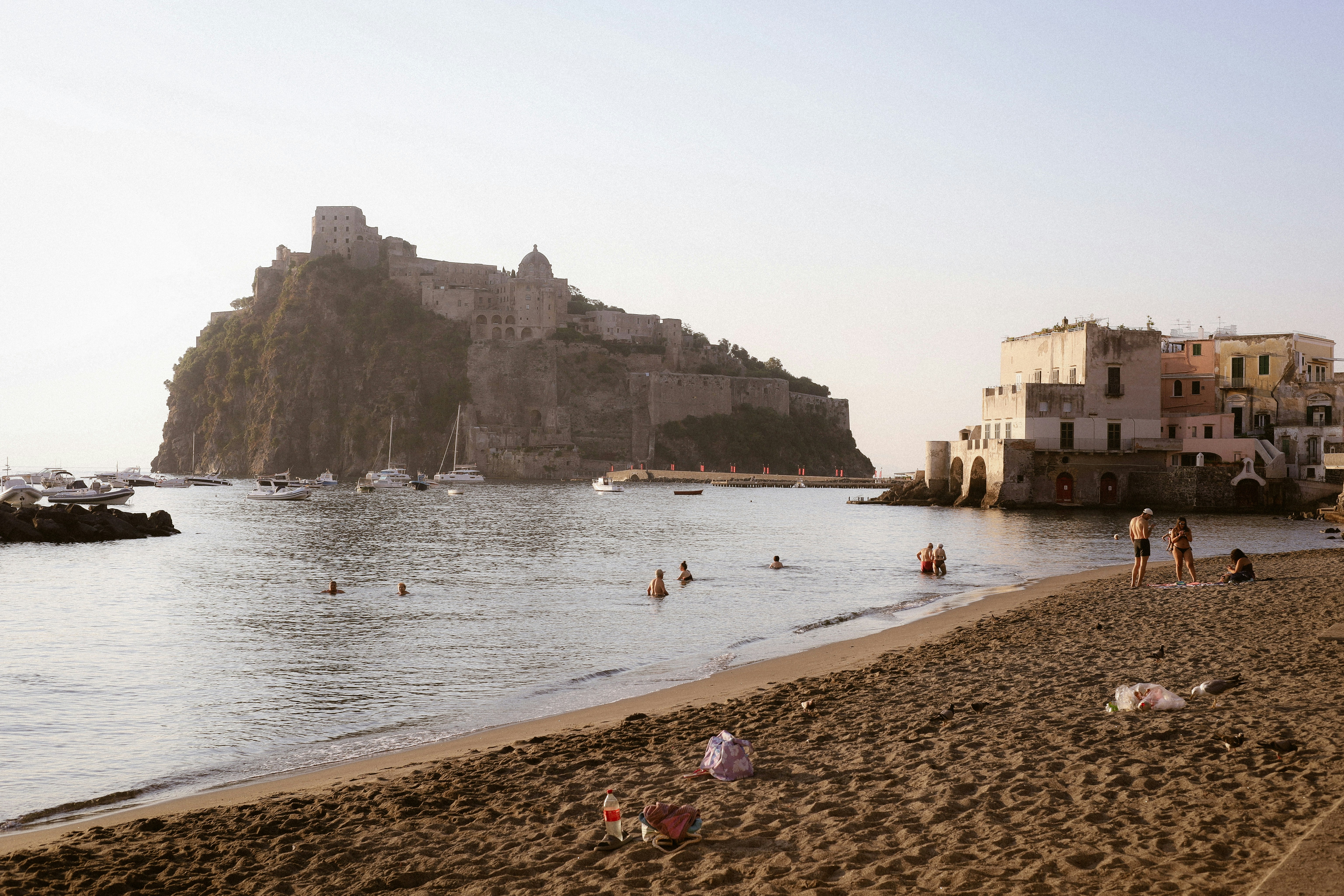 People swimming in the sea near the Castello Aragonese on Ischia island