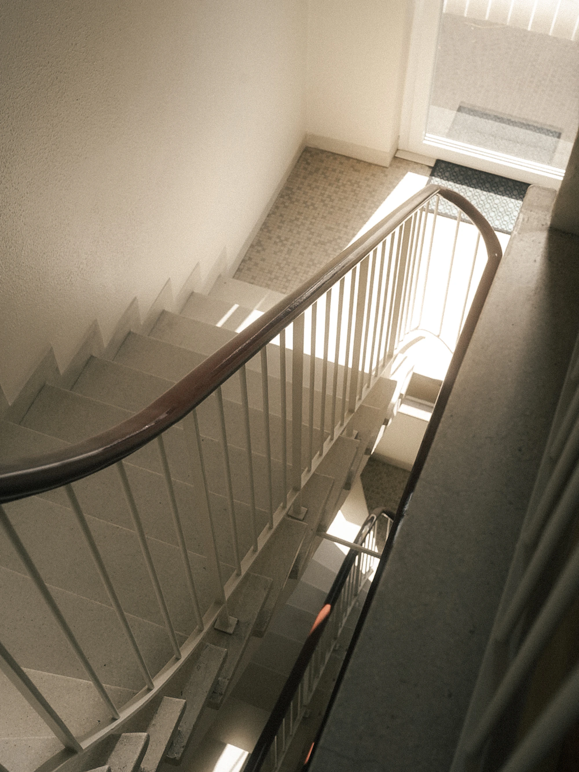 Treppenhaus eines Mehrfamilienhauses von oben, Terrazzostufen und Handlauf