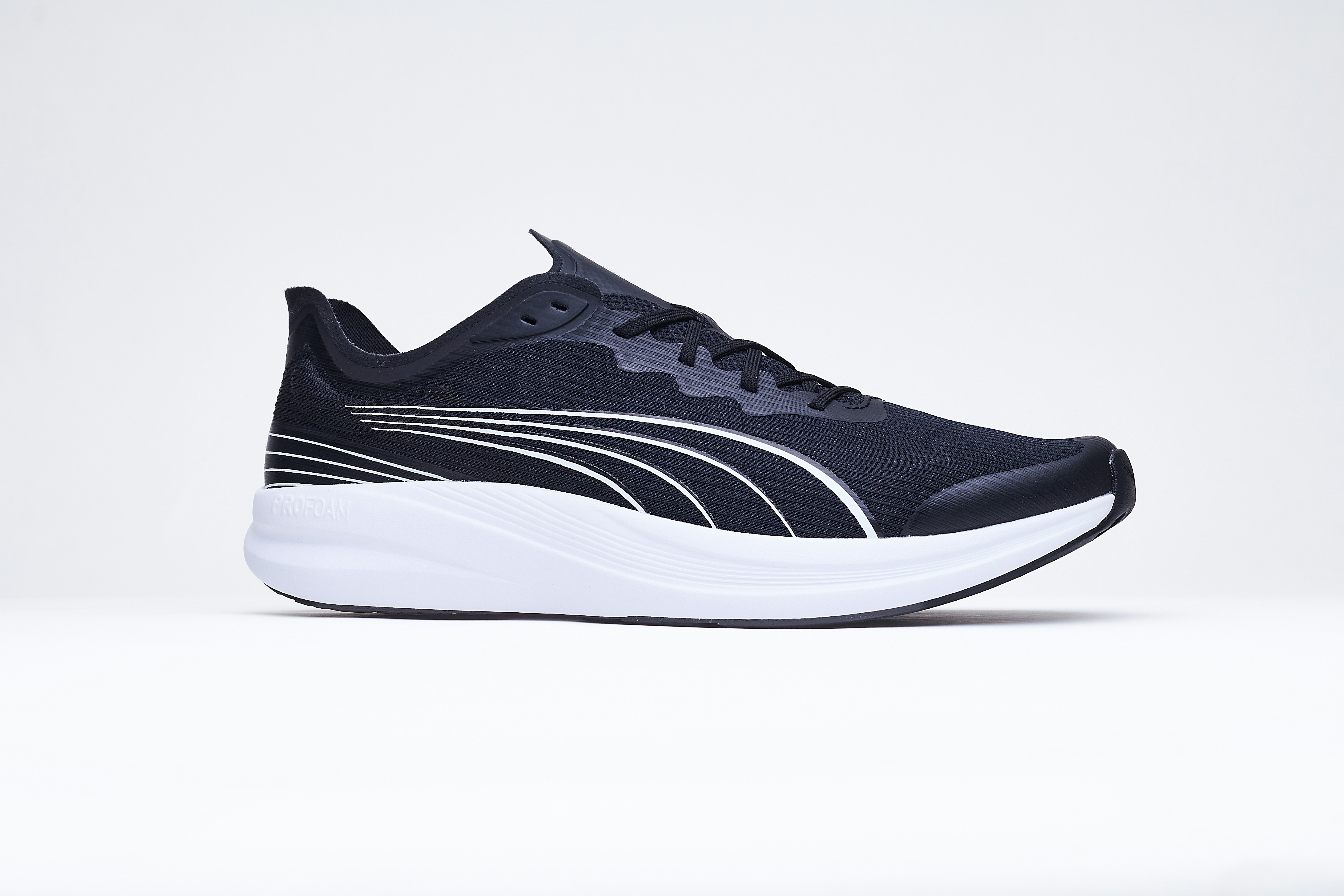 A black running shoe with a white sole on a plain background