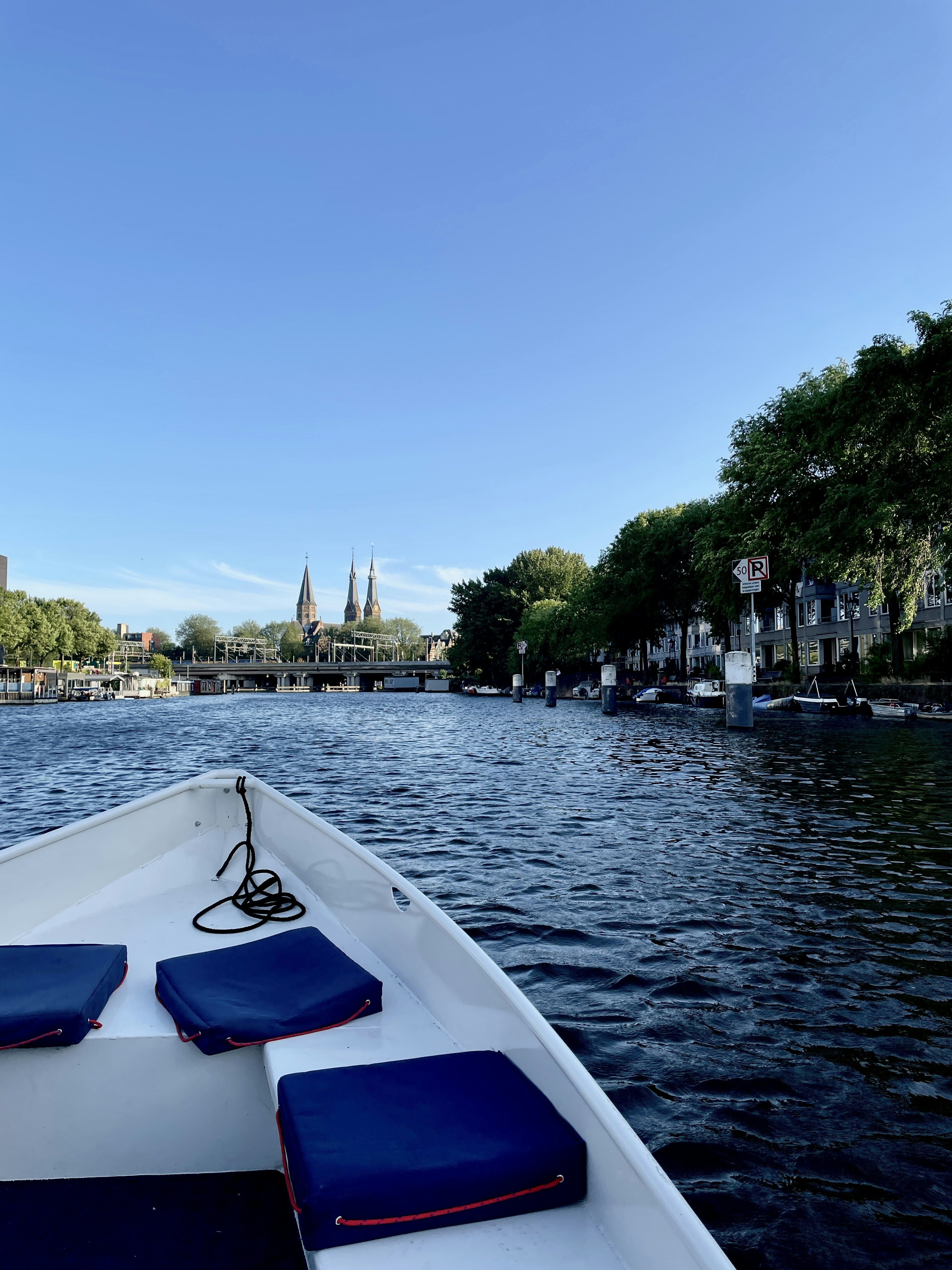 The bow of a white boat on a canal in Amsterdam, Netherlands