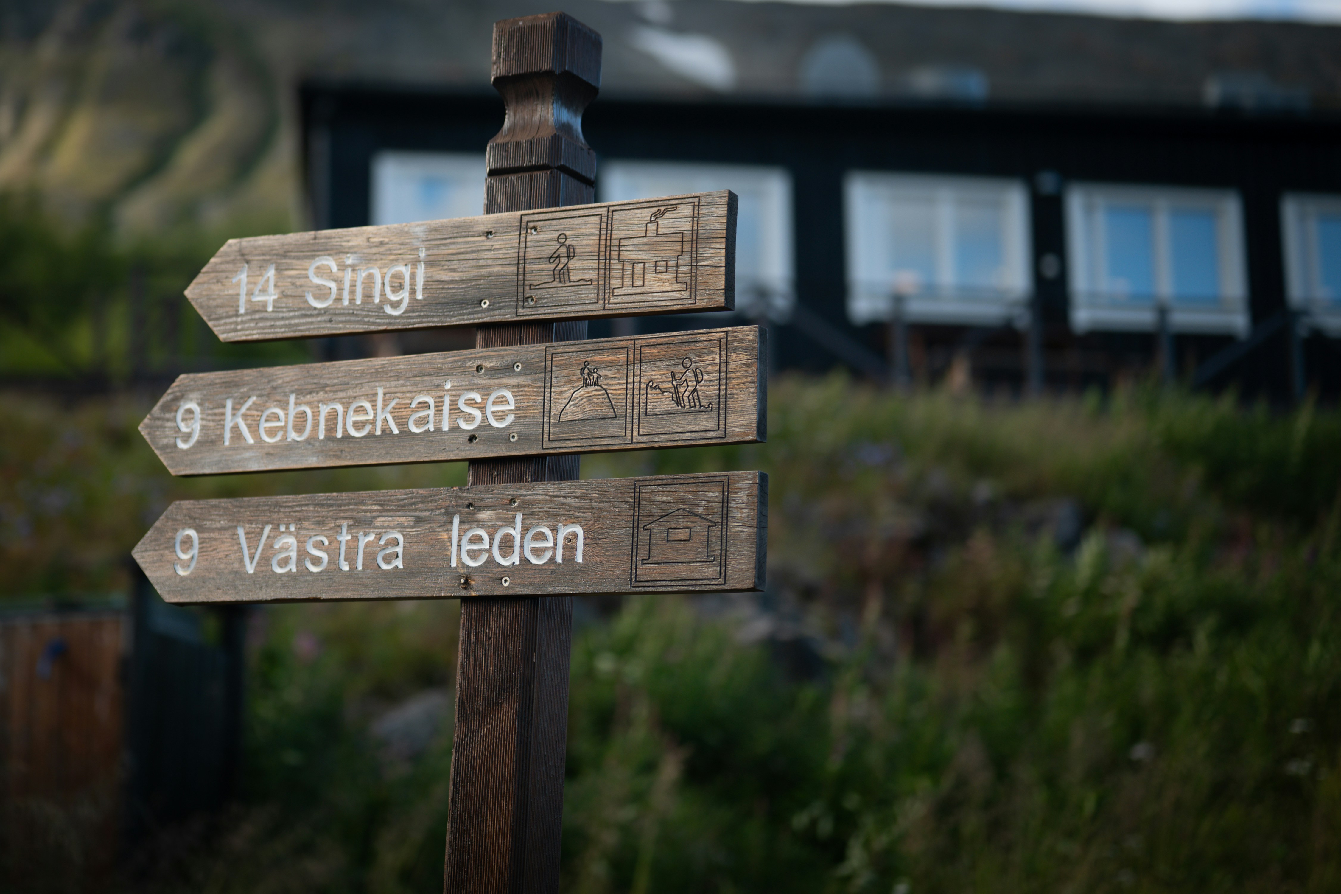 Uma placa de trilha de madeira apontando para Singi, Kebnekaise e Västra leden na Suécia