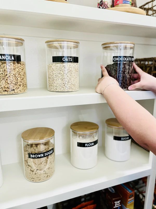 Glass jars with labels on a pantry shelf