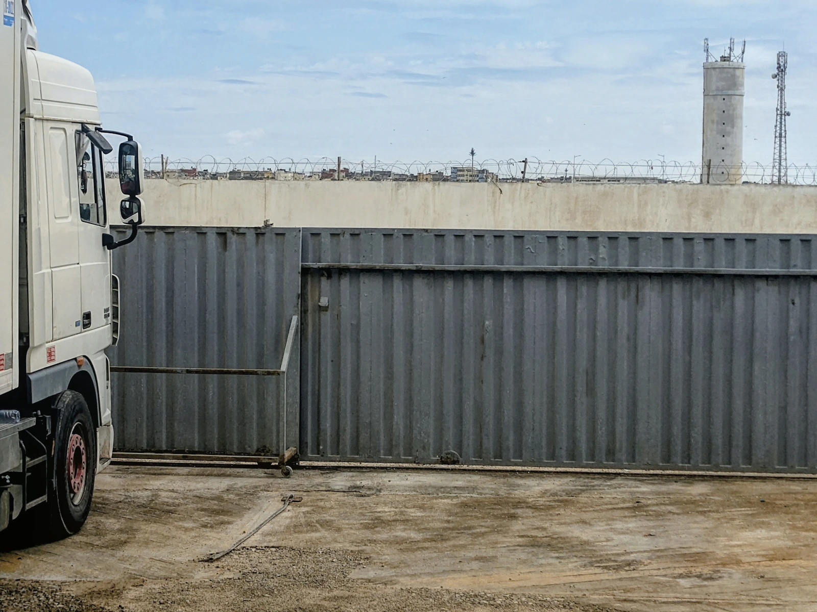 Freight truck beside an industrial gate