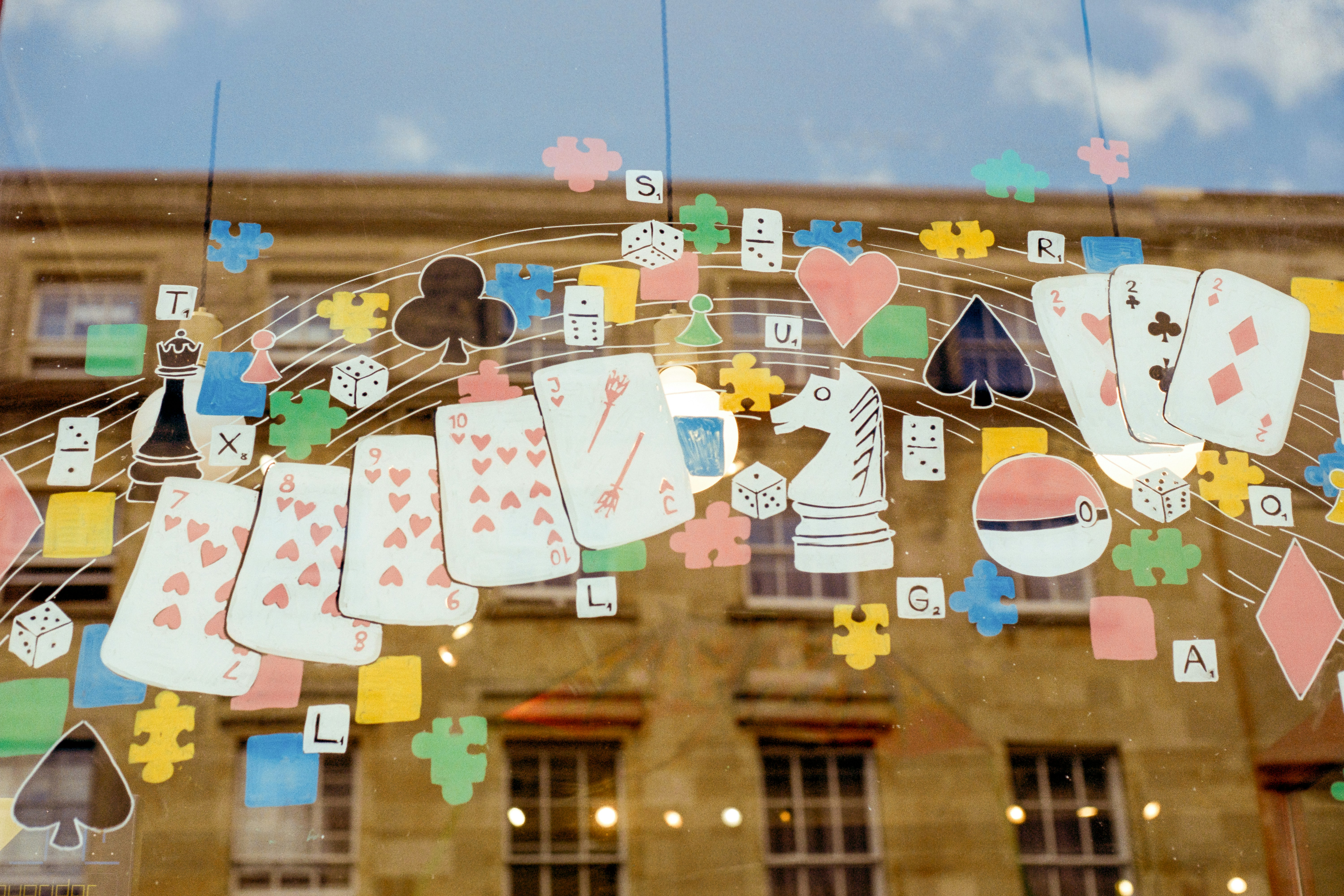 Colorful game pieces and playing cards arranged on a glass window