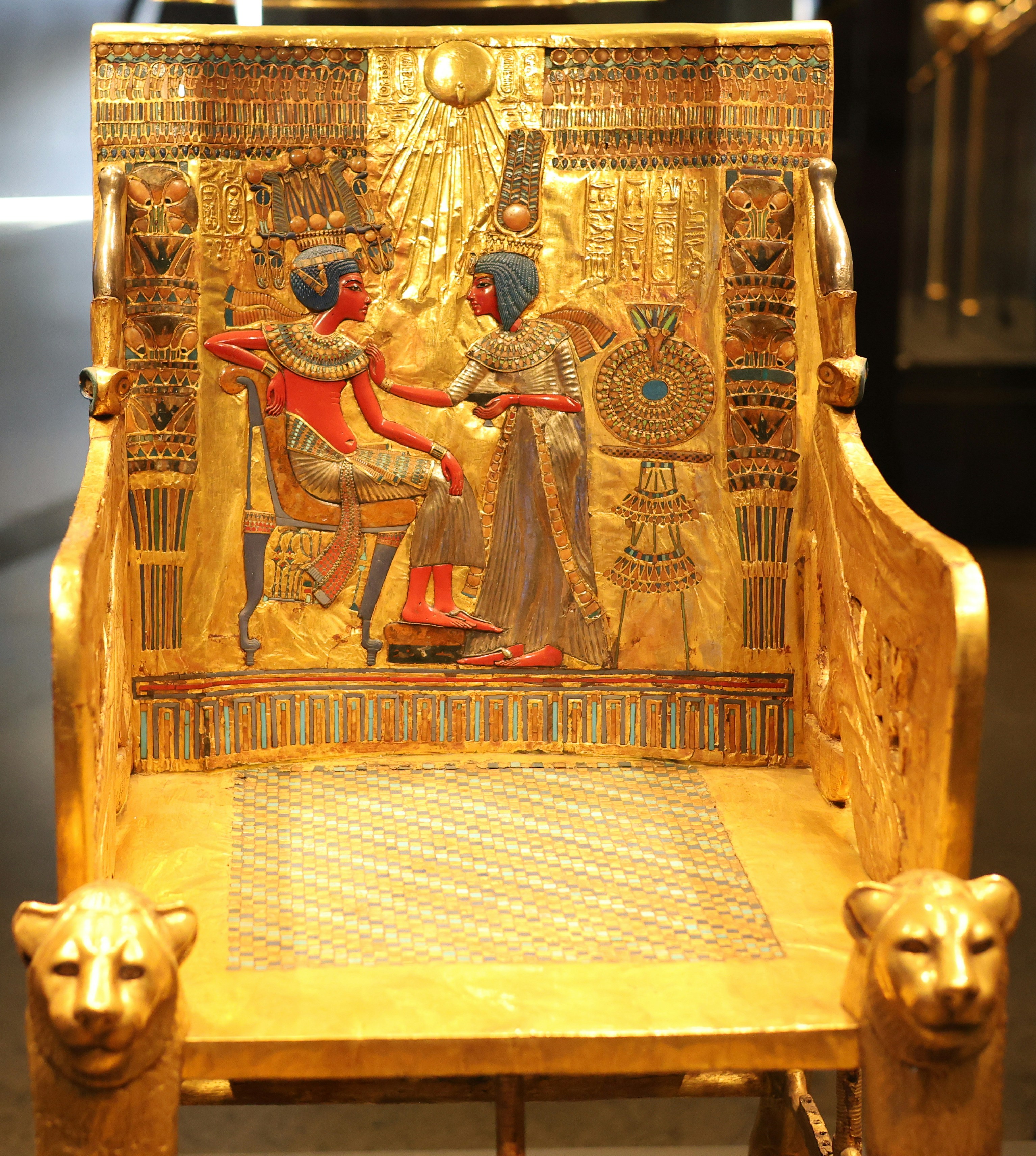 The golden throne of Tutankhamun with intricate relief carvings of two figures.
