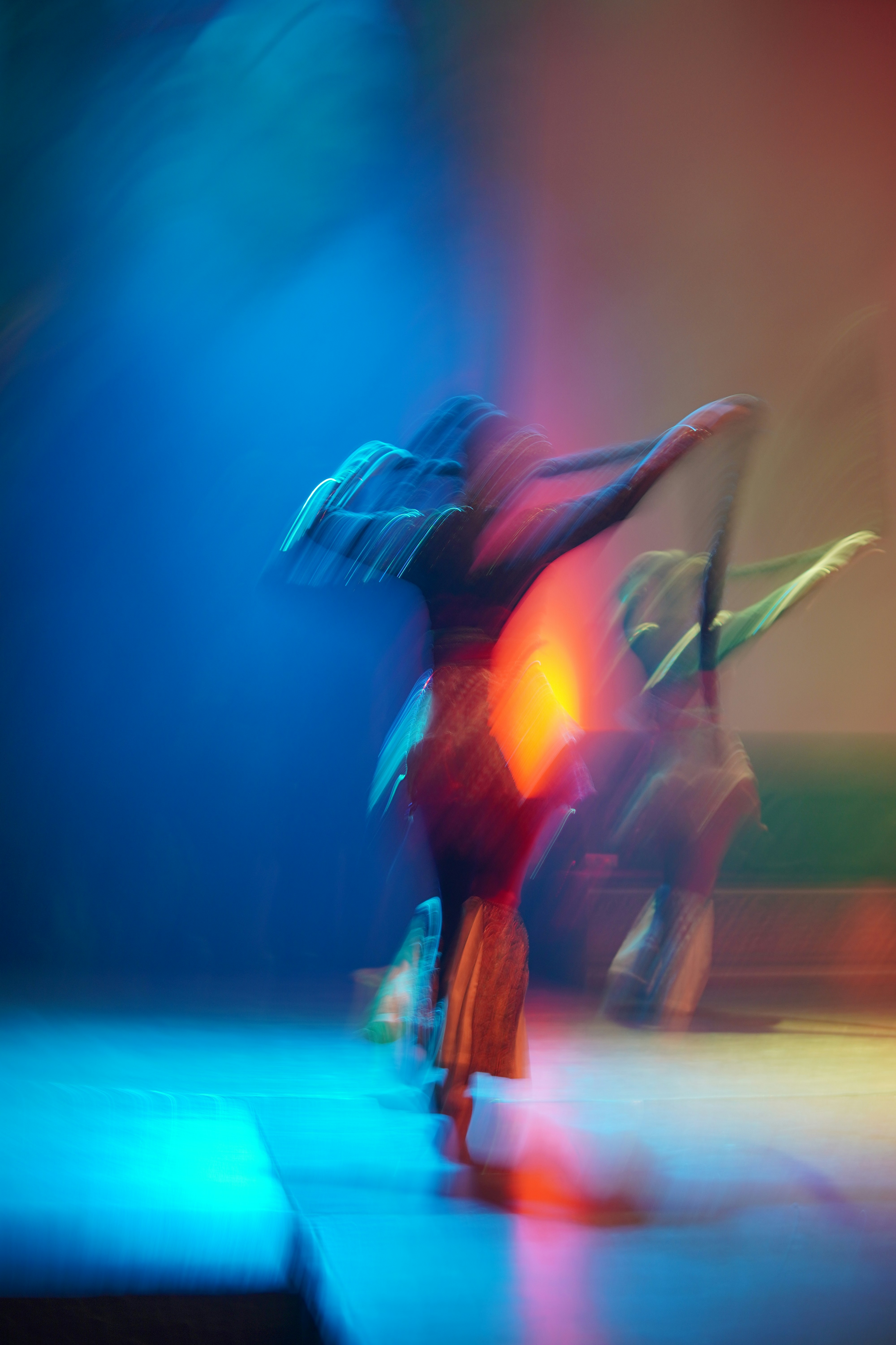 Dancers blurred into colour under stage light