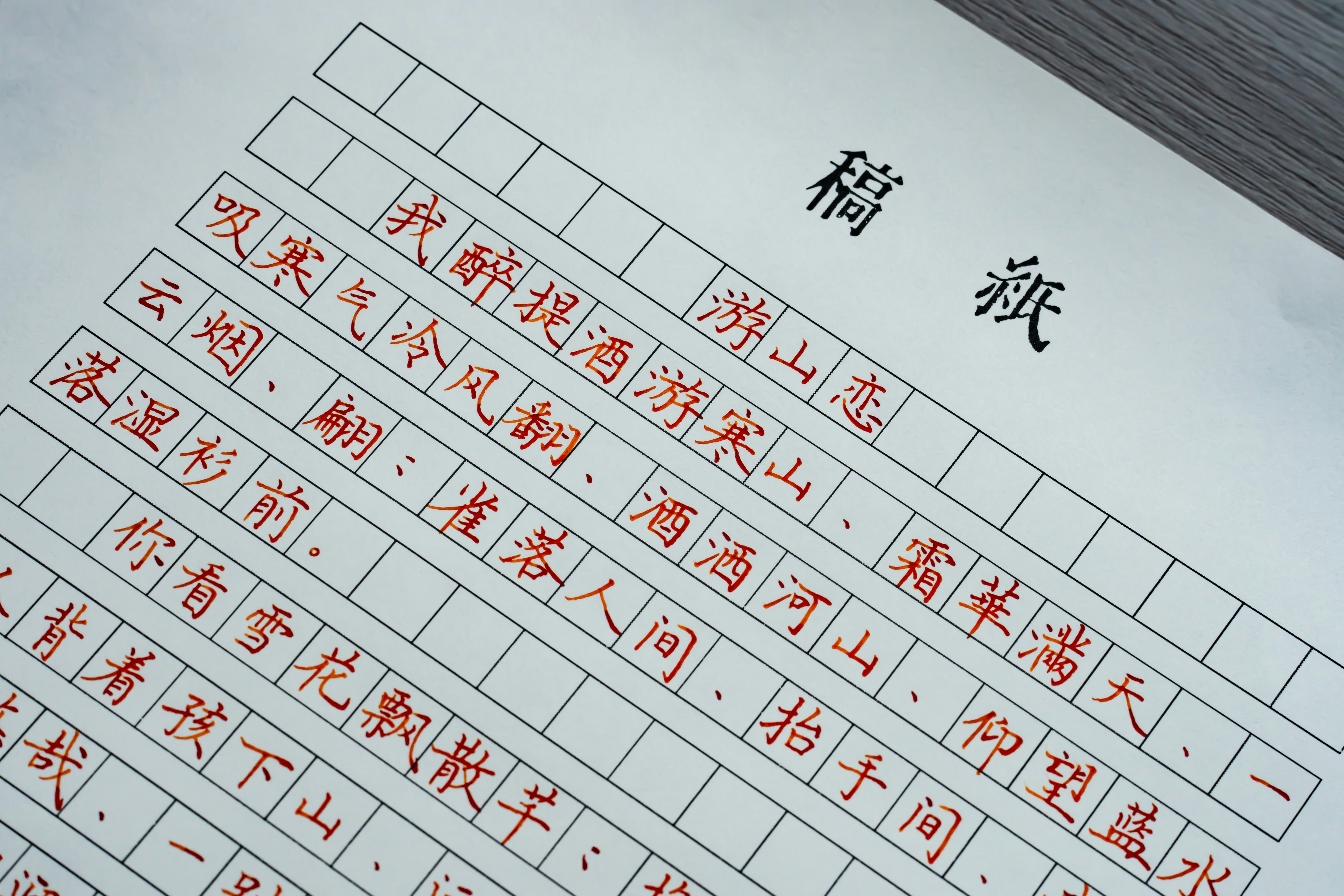 Handwritten Chinese calligraphy in red ink on a grid-lined manuscript paper