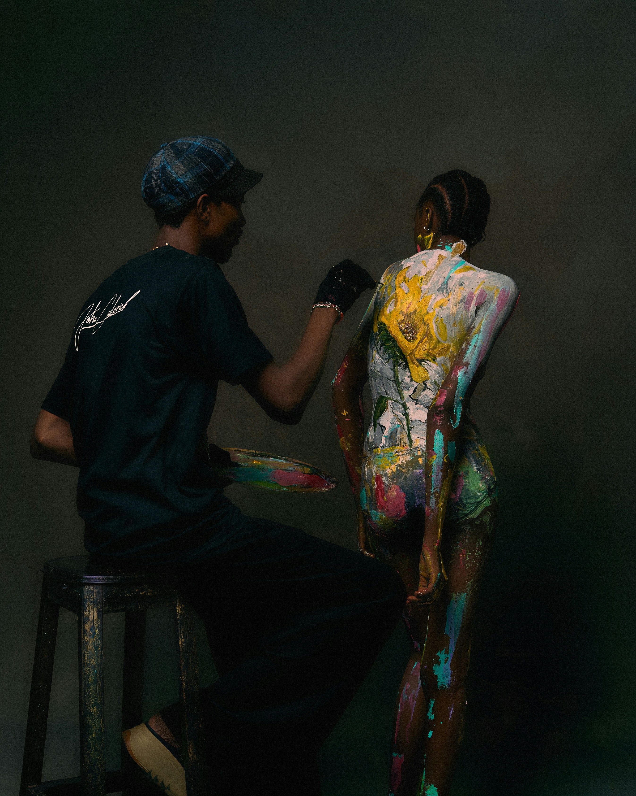 Uma pessoa pintando um desenho floral nas costas de outra pessoa