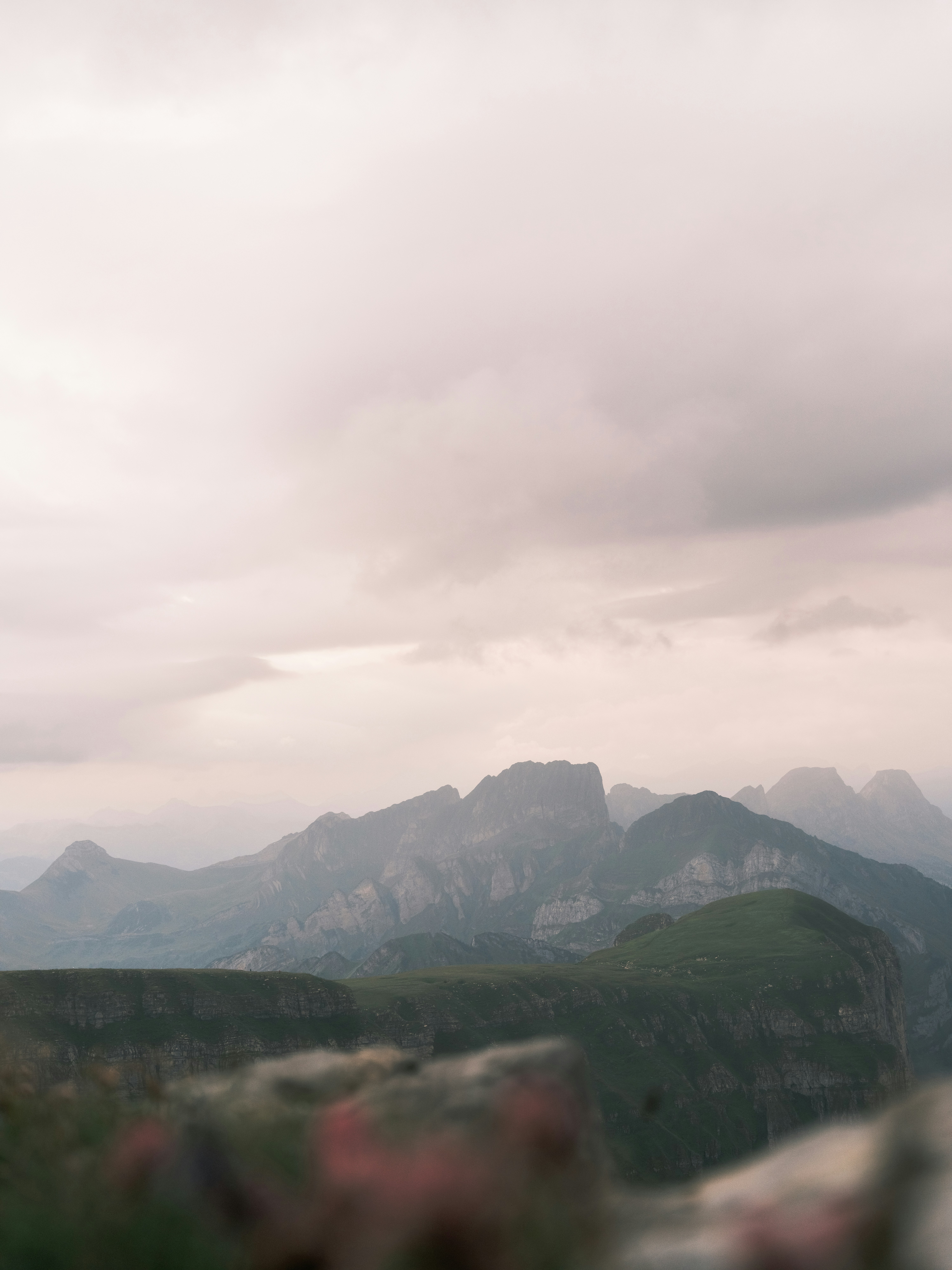 Green mountain ridges under a soft overcast sky.