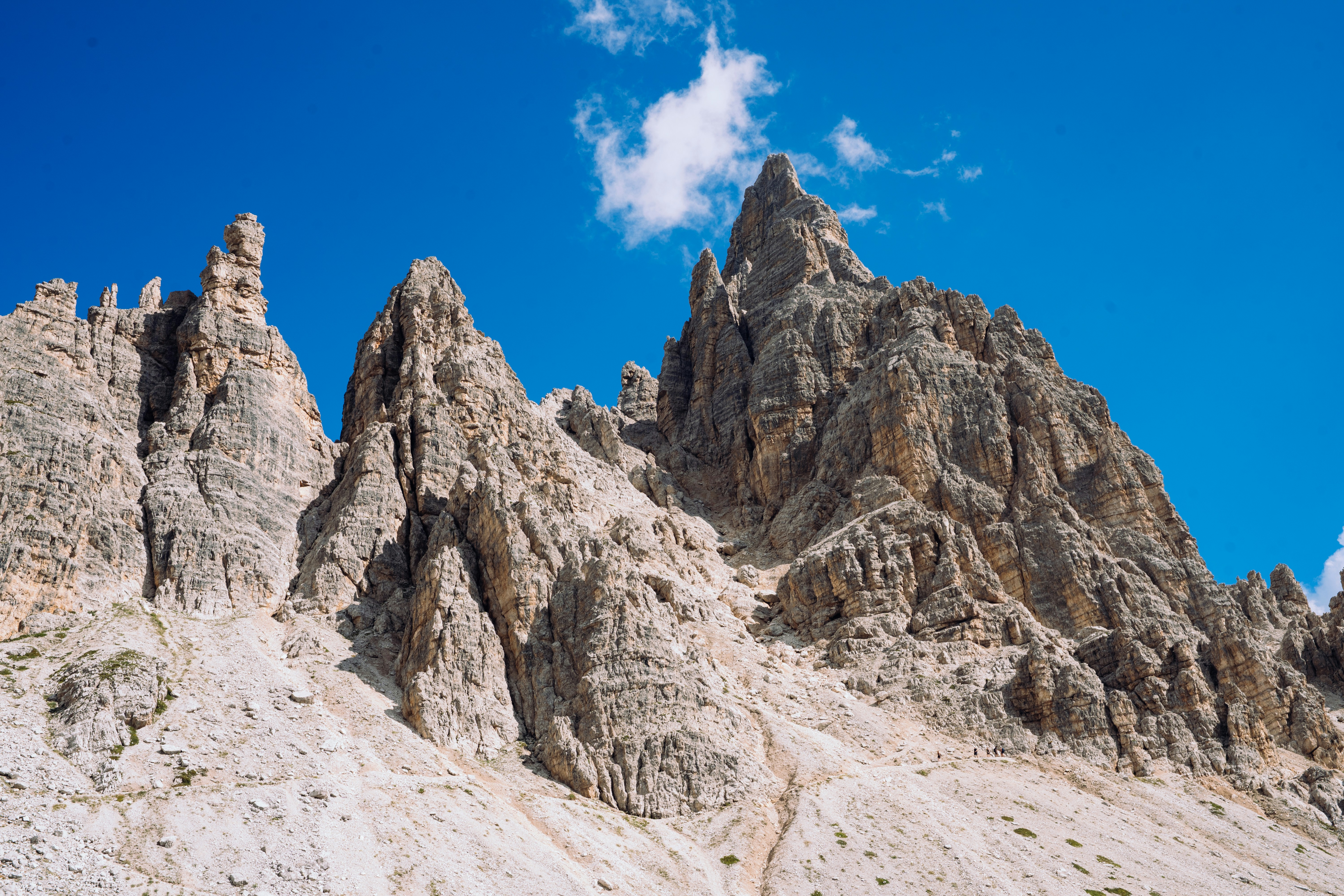 Picos irregulares de piedra caliza que se alzan contra un cielo azul claro con una sola nube