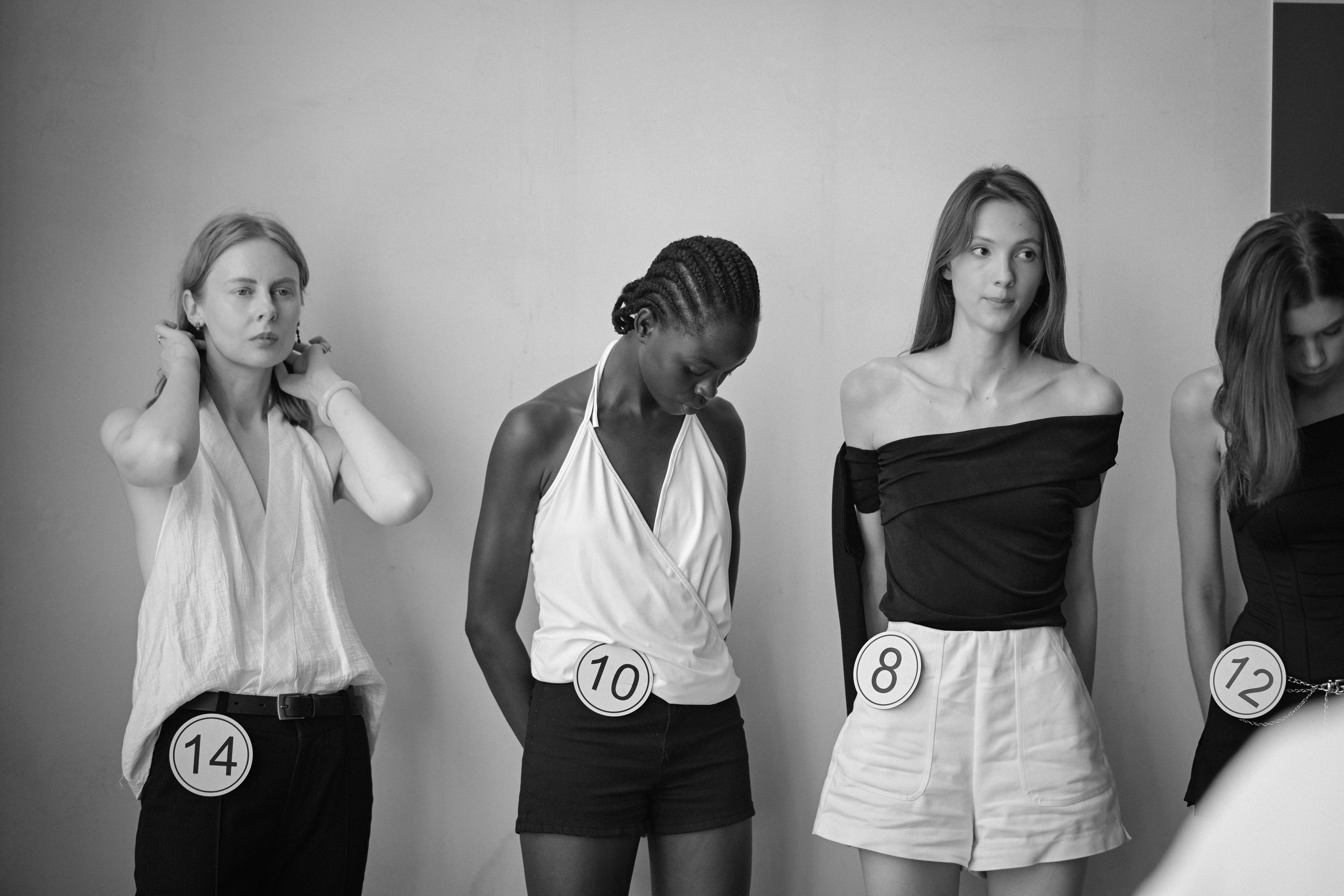 Performers waiting in line with numbered tags