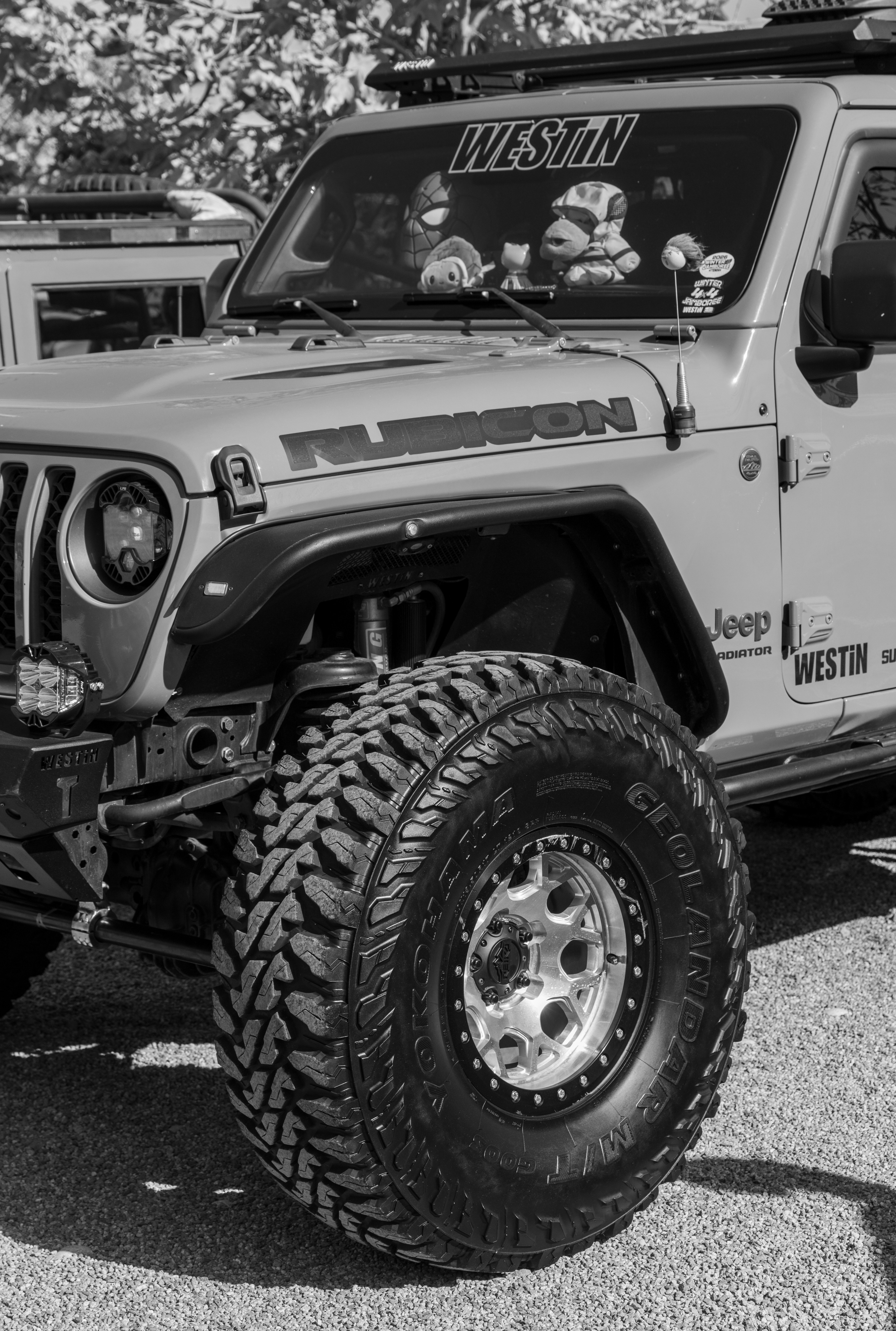 A black and white close-up of a modified Jeep Gladiator Rubicon with large off-road tires.