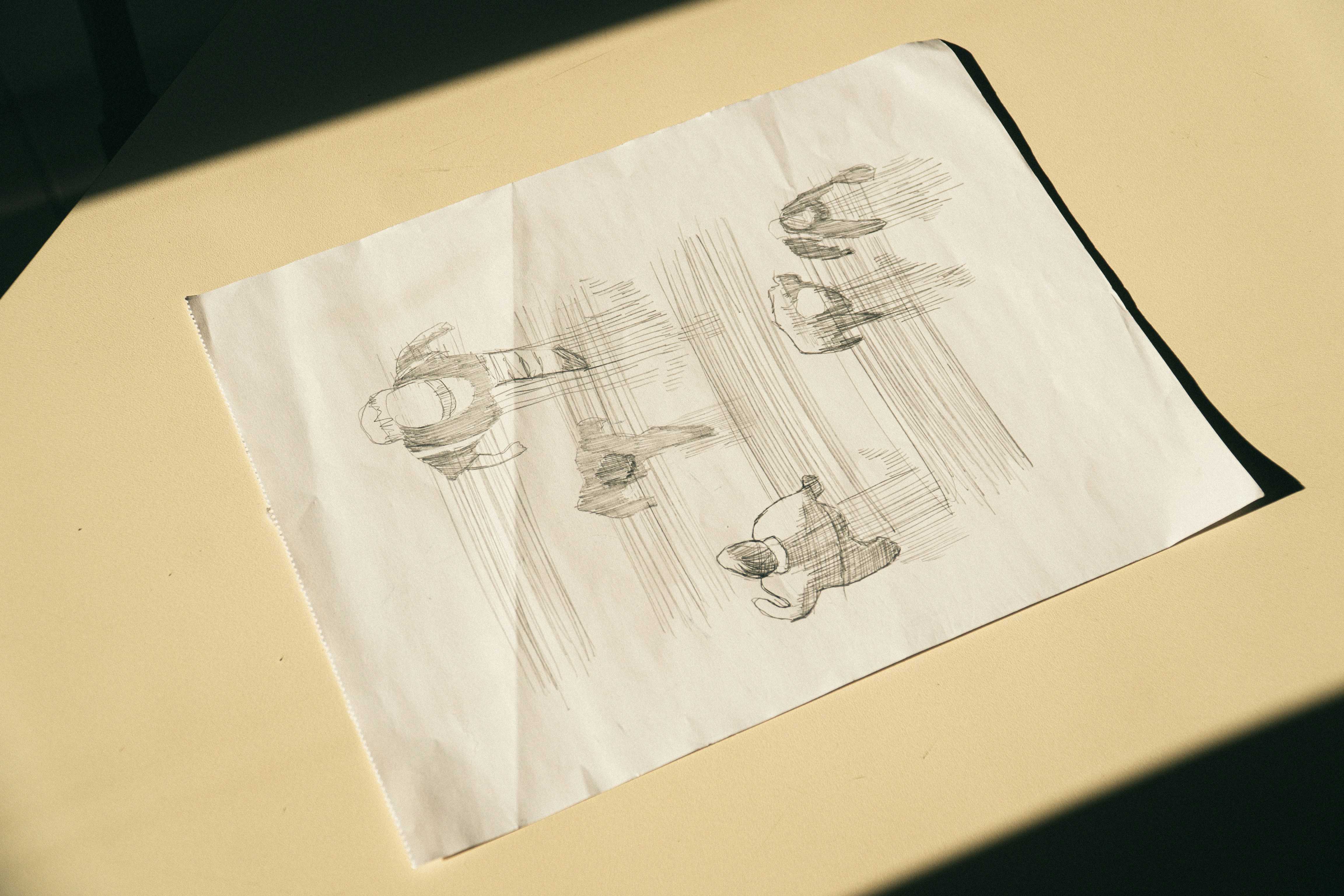 A pencil sketch of four people walking on a piece of paper.