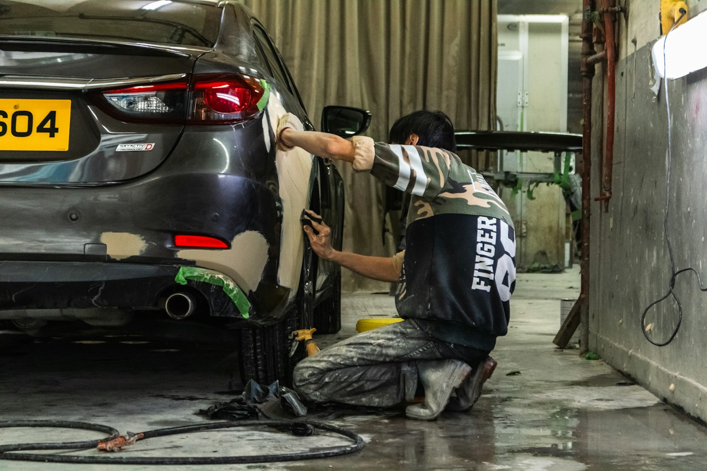 Auto mechanic working on a car engine in a repair shop